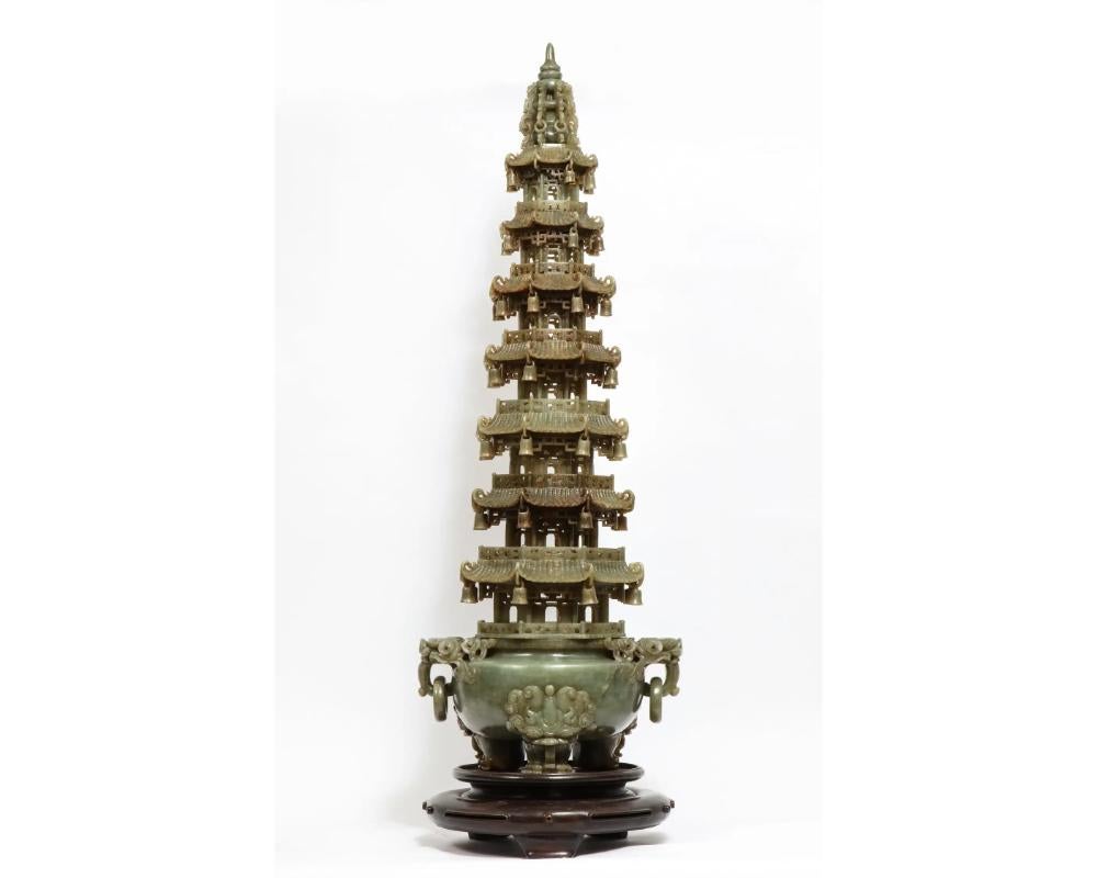 Monumental Chinese serpentine jade carved pagoda censer, early 20th century.

A masterfully carved Chinese serpentine pagoda censer. The base of the tripod censer is set upon lion-headed paw feet. Two loose ring handles hang from the mouths of