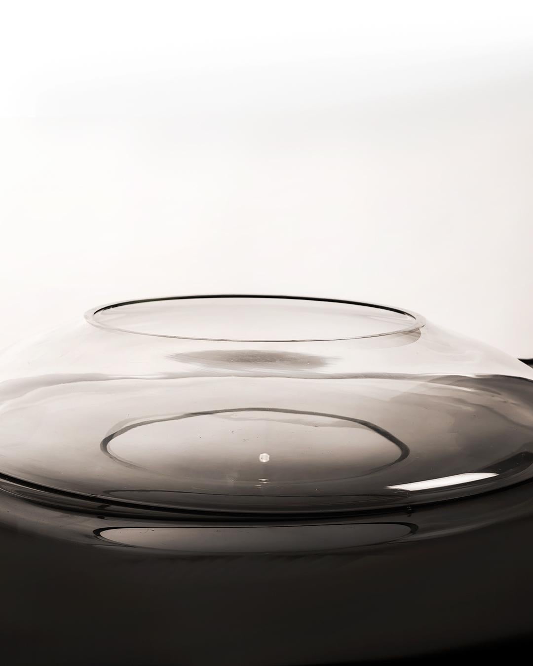 Dieses monumentale Stück (64 × 60 × 11 cm) ist ein Beispiel für die skulpturale Klarheit und den raffinierten Minimalismus des italienischen Glasdesigns der Nachkriegszeit. Die aus transparentem Kristallglas gefertigte, fließende Silhouette fängt