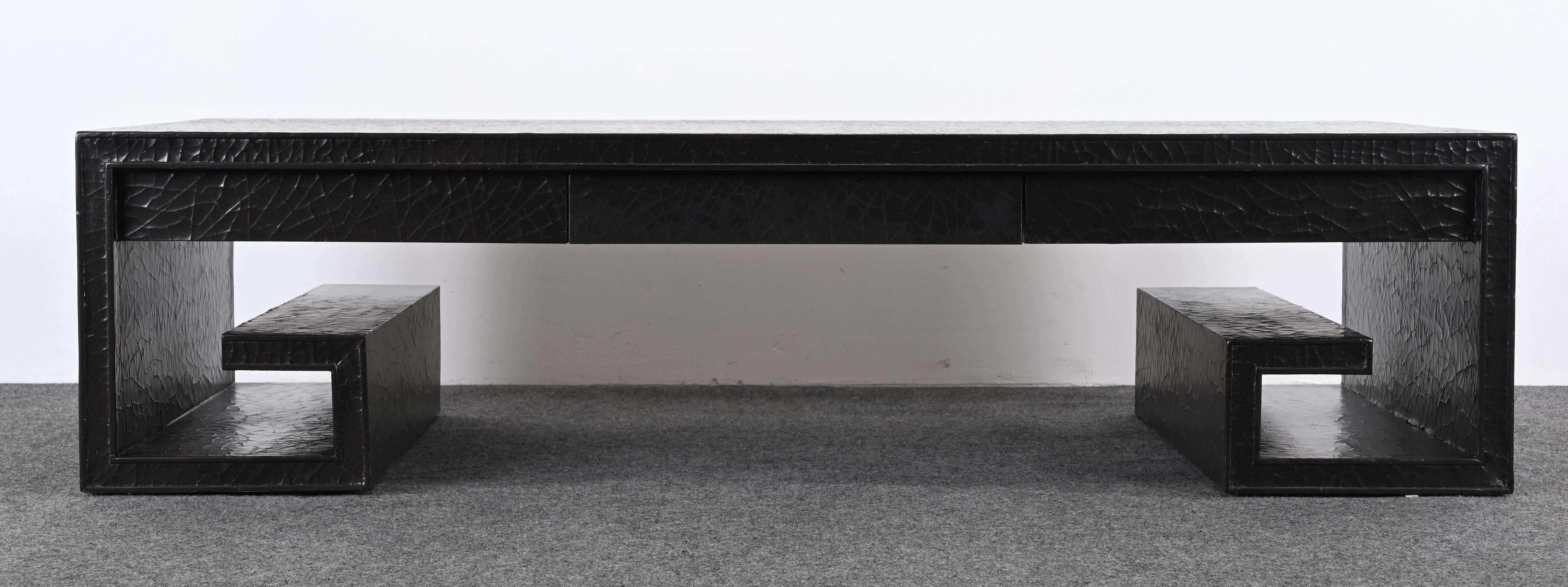 A monumental stunning black lacquer-painted coffee or cocktail table designed by Thomas Pheasant for Baker. The Greek Key motif adds a nice design element. The coffee table also has two drawers for ample storage. The Baker label is inside the drawer