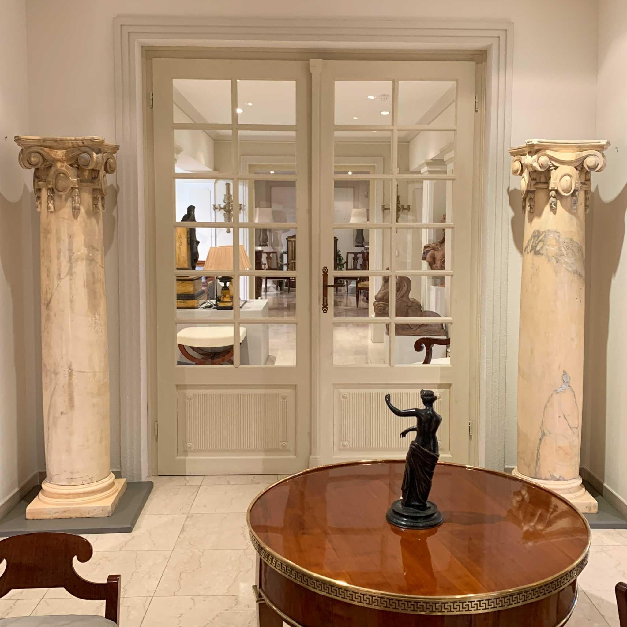 Pair of yellow Italian marble columns on profiled base and curved crowning capitals.