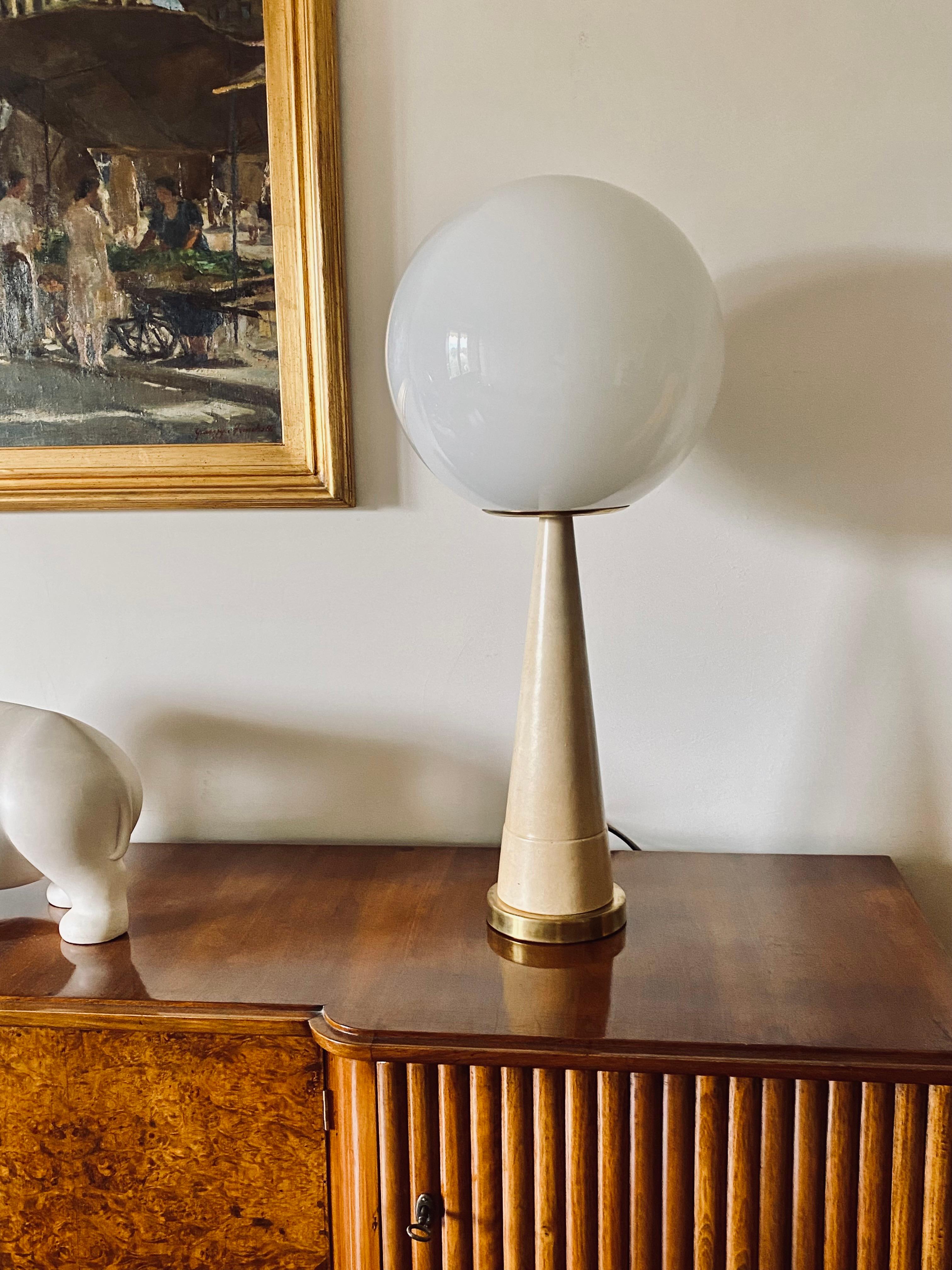 Monumental Midcentury table lamp

France 1960s

Conical base in brass and cream-coloured parchment. Milky glass sphere.

Height 80 cm - 36 cm diameter.

Conditions: very good consistent with age and use. Defects on the parchment.