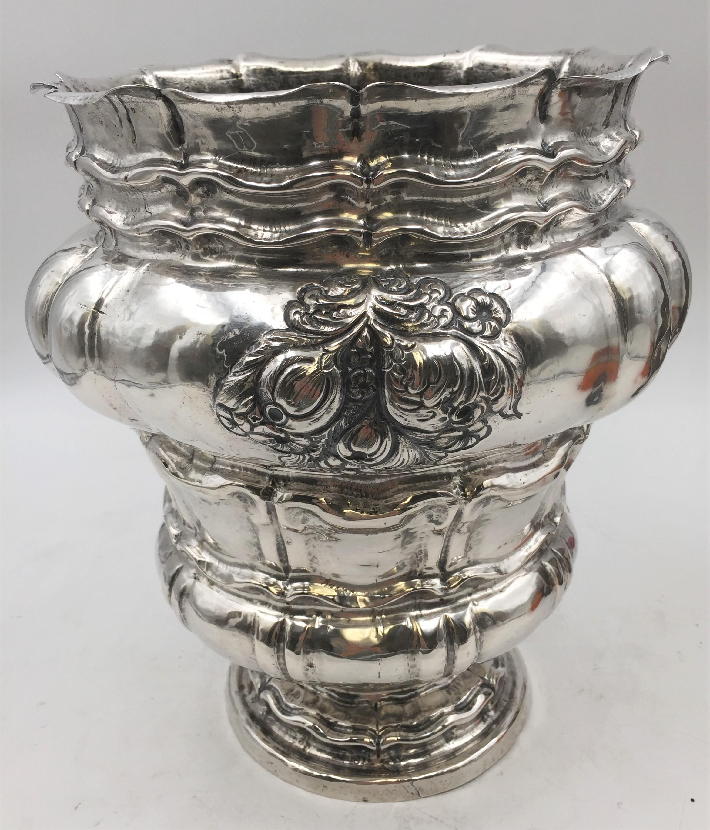 Continental silver wine cooler or vase, probably from the 19th century, with ornate floral and twirling motifs. It measures 11 1/8'' in height by 8 1/2'' in diameter at the top (10 1/2'' at the widest point approximately), weighs 42.5 ozt, and bears
