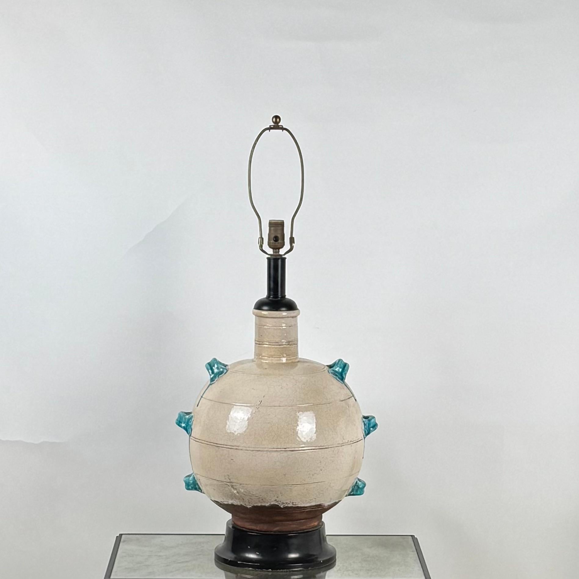Monumentale lampe en céramique émaillée crème et turquoise.
Base uniquement ; pas d'abat-jour.
La hauteur indiquée (36 pouces) correspond au sommet de l'épi de faîtage.
La hauteur jusqu'au sommet de la partie en céramique de la base est de 21 pouces.