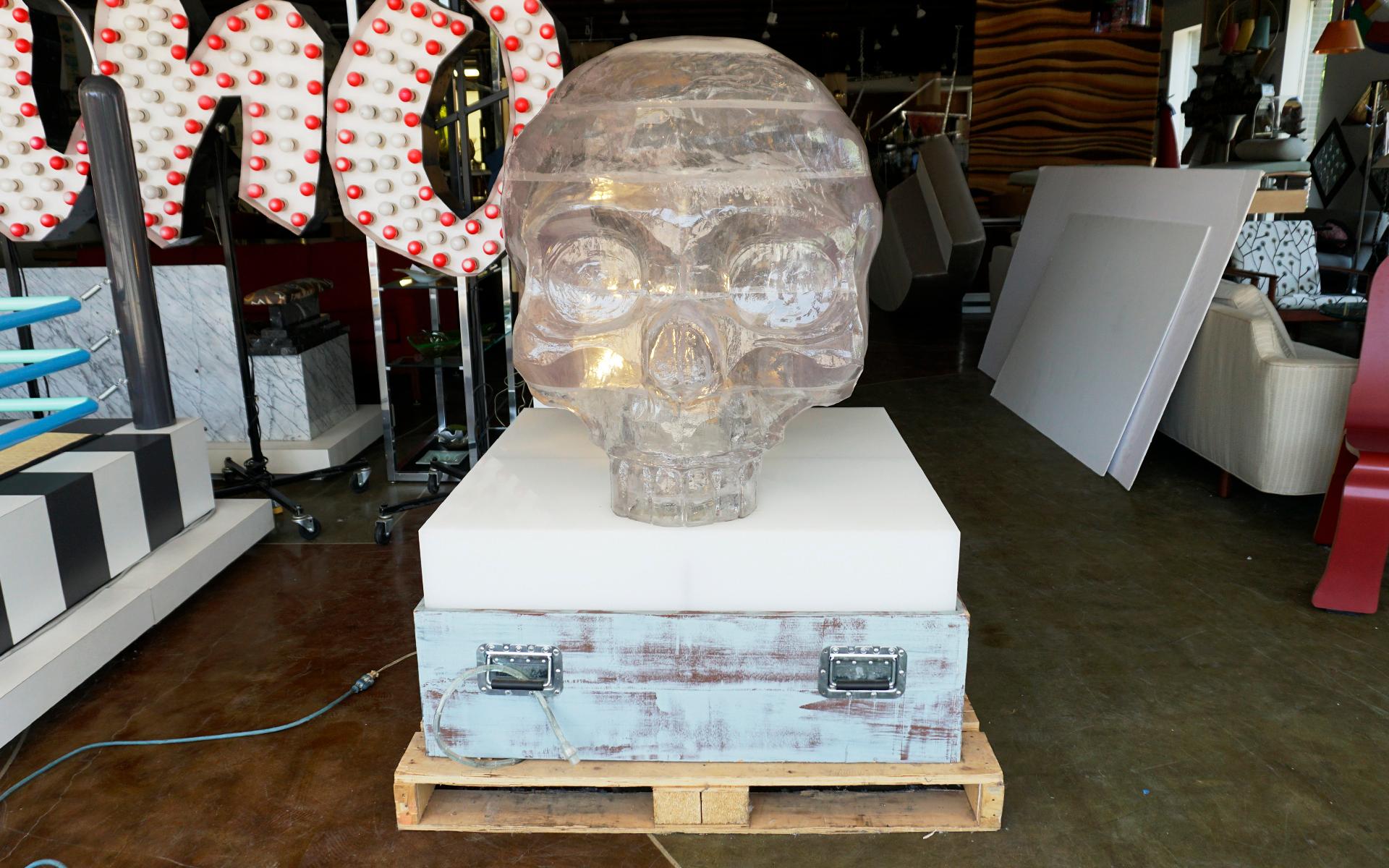 Huge, one of a kind acrylic resin skull. Mounted to a light box and base with handles for moving. There is a cavity inside the skull in which a light can be placed if so desired. One of a kind.  The skull itself is 36 inches tall, 32 inches wide and