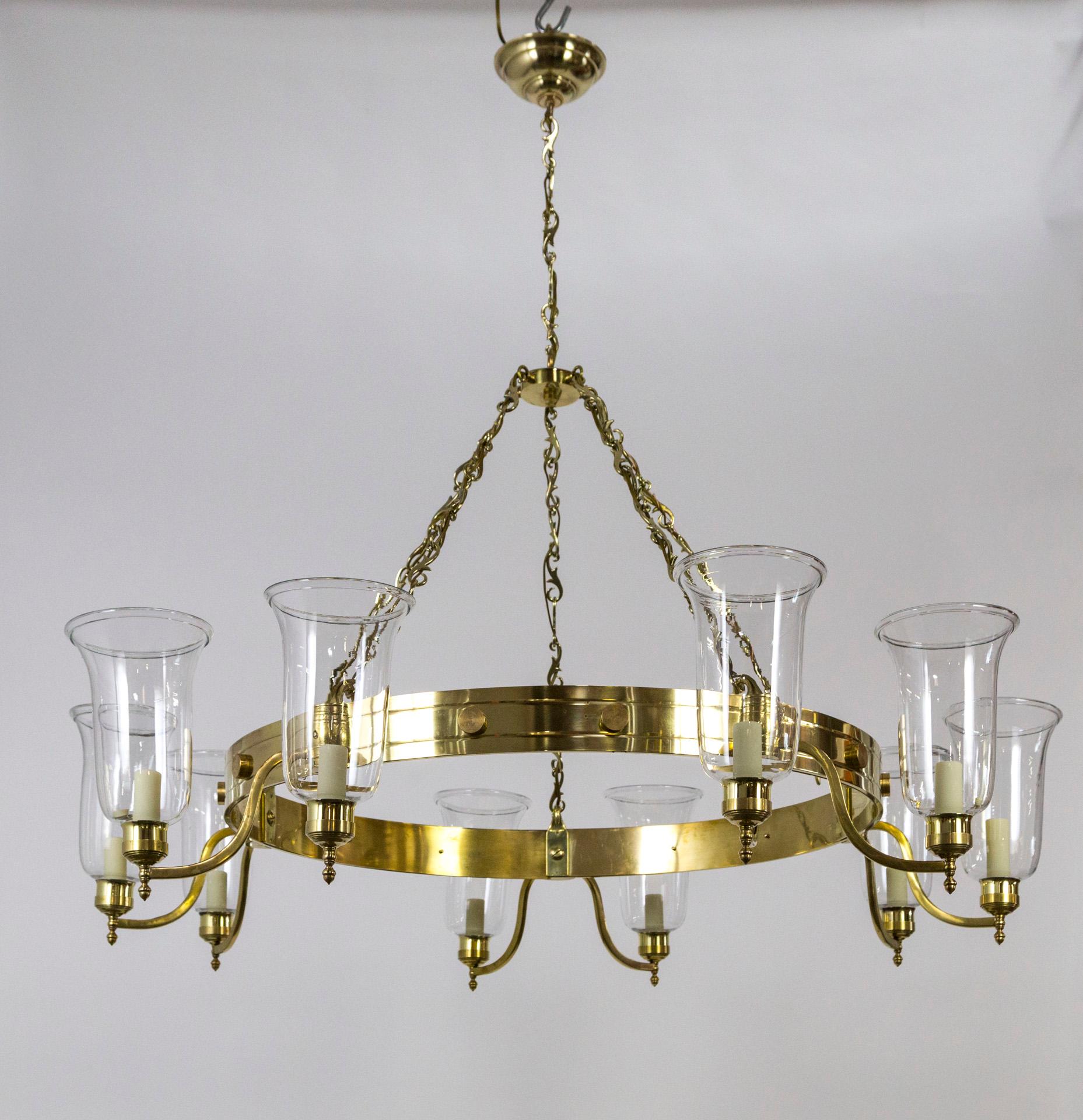 A massive, quality crafted, solid brass chandelier with fine, hurricane glass shades. Individually crafted undulating arms with barrel accents. The raw brass will patina beautifully. Measure: 48.5