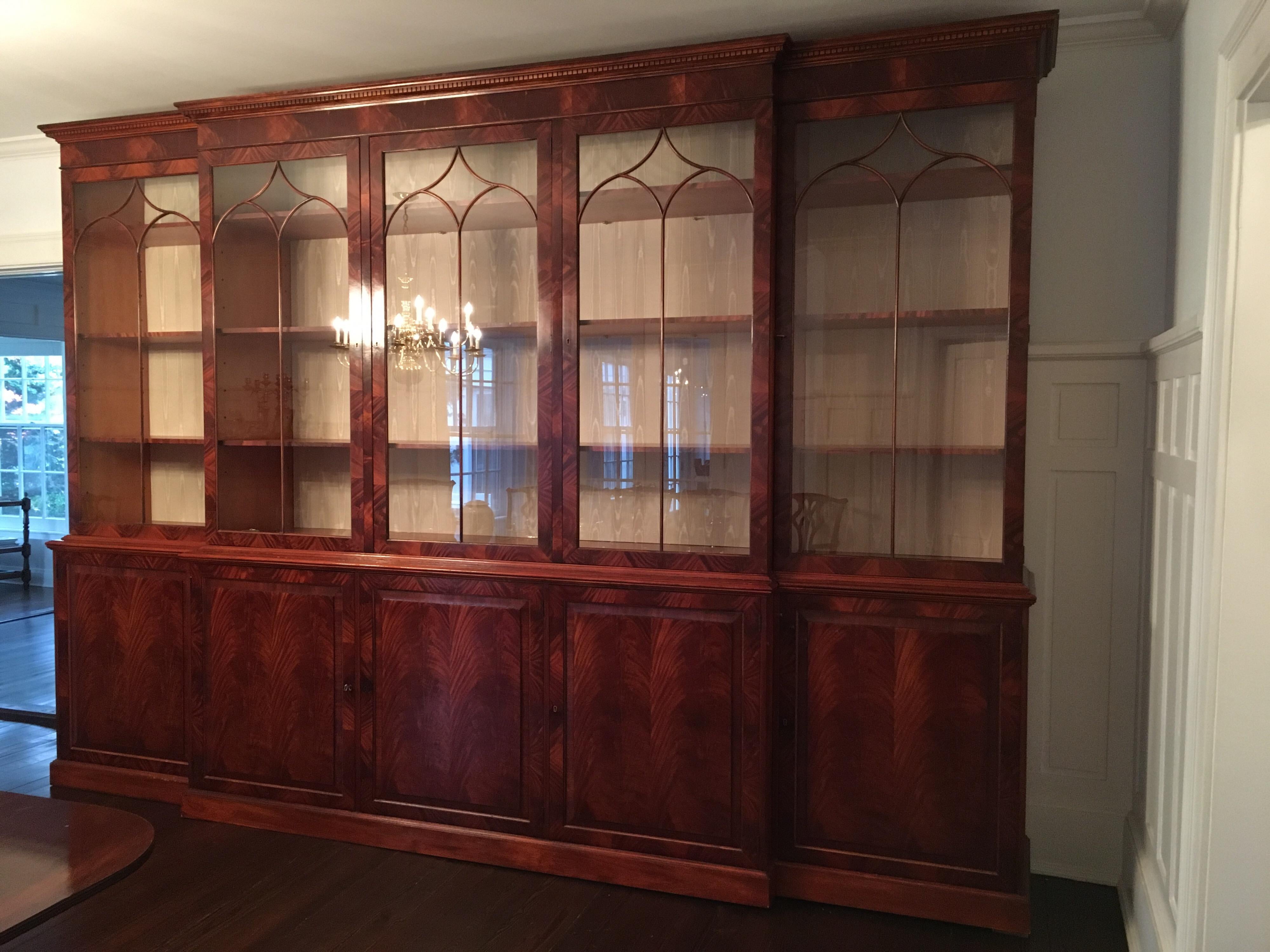 Monumental custom made mahogany breakfront bookcase by Mill House Antiques. A stunning Sheraton style reproduction made by Mill House Antiques in Woodbury, CT. Gothic arched glazed doors and adjustable shelves above doors with more adjustable
