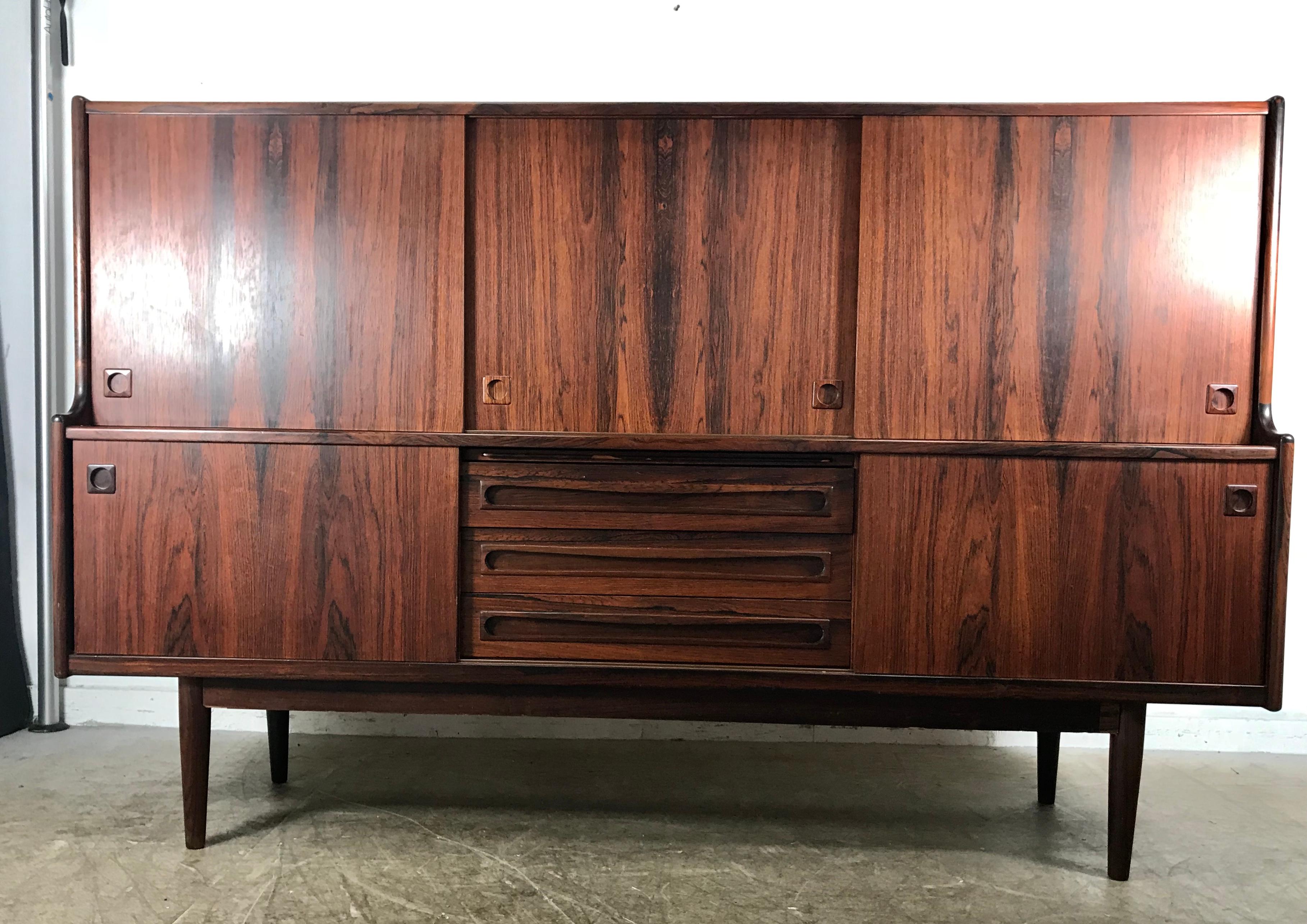 Iconic solid rosewood credenza manufactured by Omann Jun of Denmark in the late 1950s. This particular piece in amazing original condition with almost no issues to speak of. It features five sliding doors and four smooth dovetail drawers. (Bottom)
