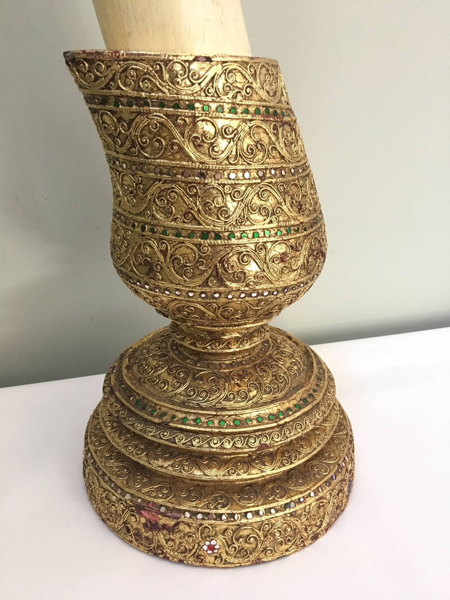 Large decorative faux elephant tusks feature intricate gold gilt bases decorated with sparkling gems. Solid wood construction. Excellent vintage condition with abrasions to finish that actually compliment the realistic look.