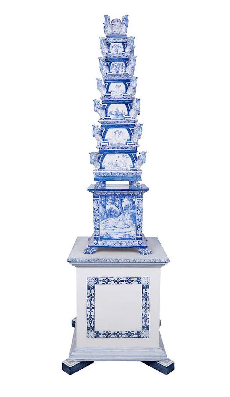 Large Dutch Delft blue and white porcelain eight-tiered pyramidal tulipiere. The porcelain pedestal is supported on lion's paw feet and painted with mythical scenes. Each tier with four molded dolphin spouts at the corners and decorations depicting
