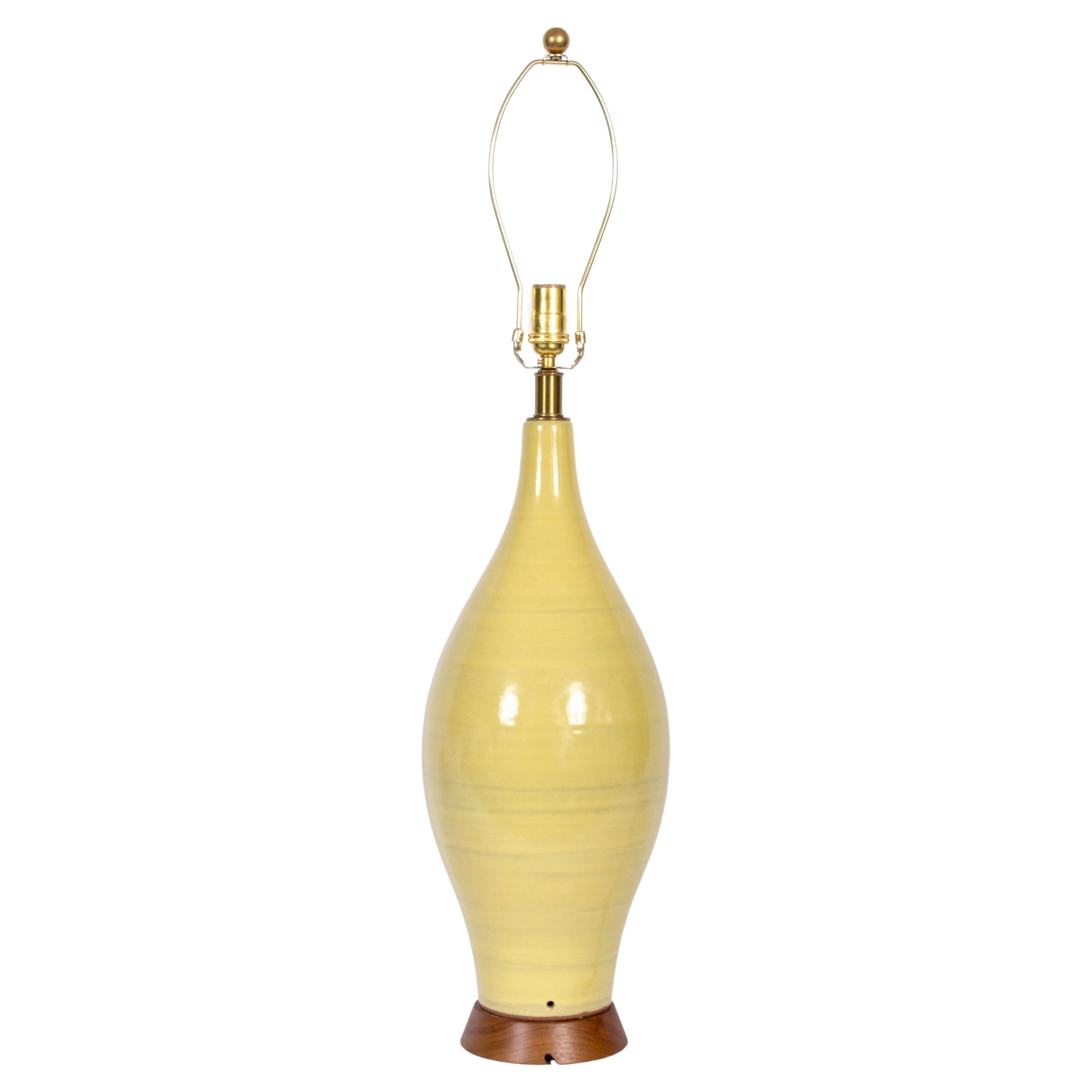Sustancial lámpara de cerámica amarilla vibrante Design Technics artesanal de 3'H, años 60.  Con la clásica forma de botella esculpida a mano con bandas verticales y esmalte brillante reflectante sobre una sólida base de nogal acampanada. 28 H hasta
