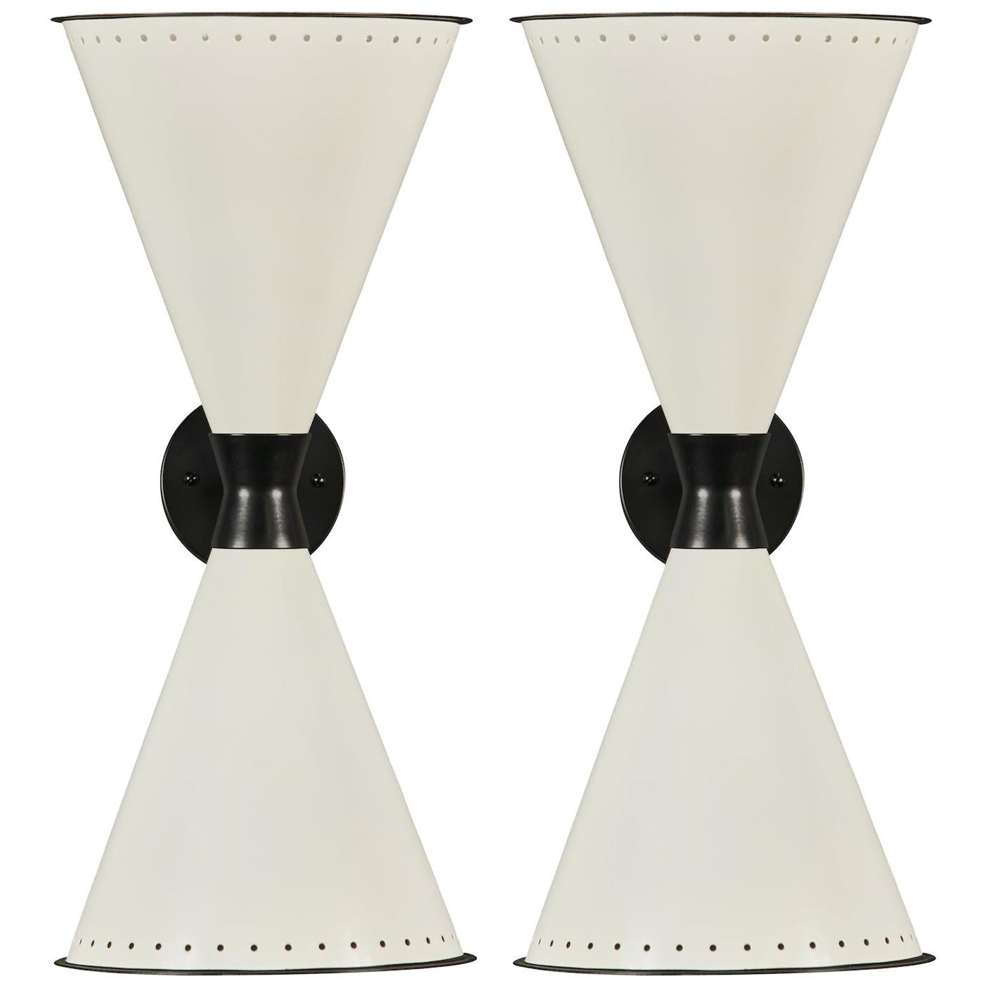 L'applique monumentale à double cône perforé 'Diabolo' en blanc et noir. Fabriqué à la main à Los Angeles avec une attention scrupuleuse aux détails et aux matériaux. Exécuté dans des abat-jour en métal laqué de haute qualité, ce design