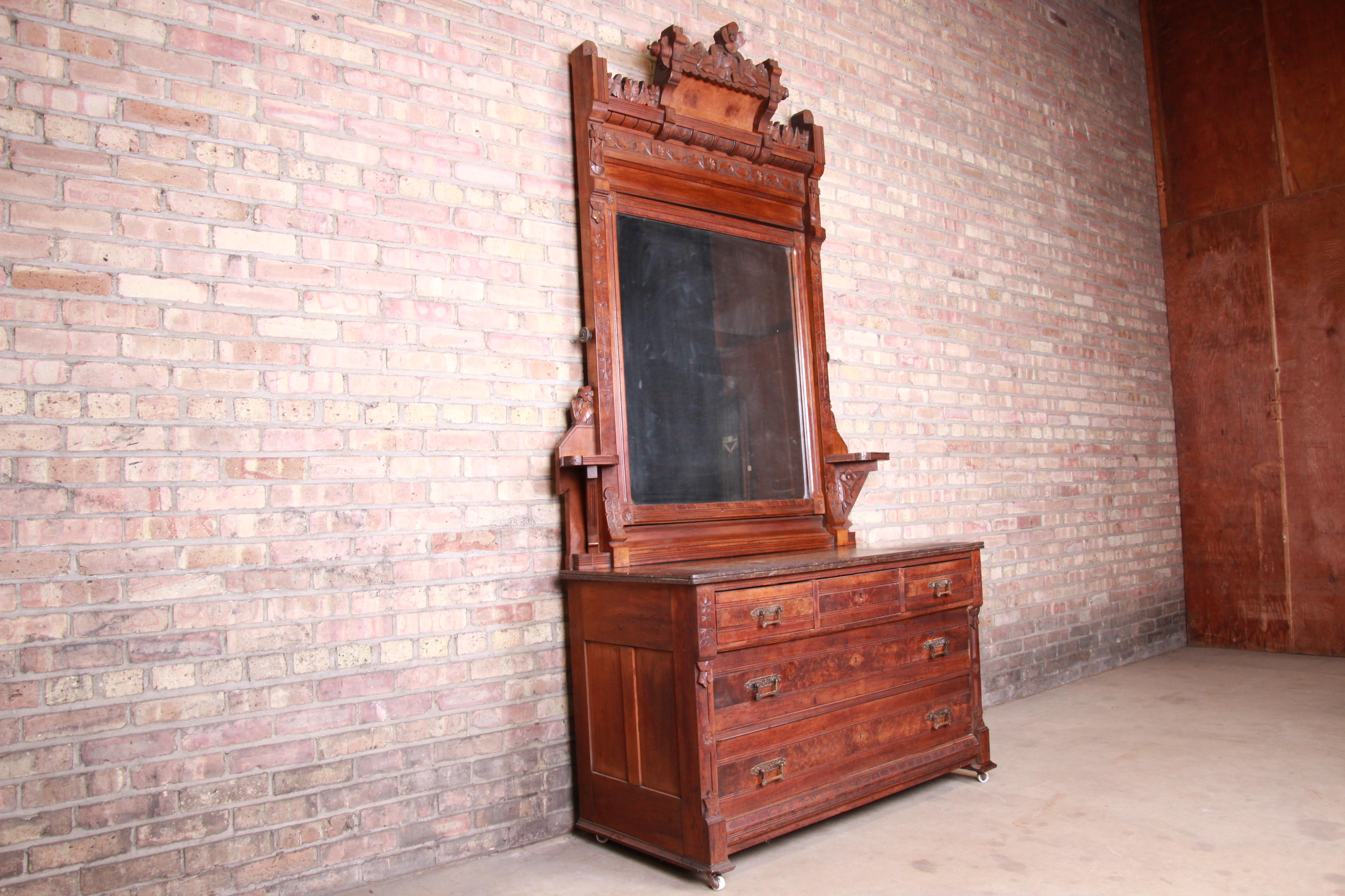 A rare and outstanding Victorian Eastlake five-drawer dresser with mirror

Originally purchased from Marshall Field's in Chicago, circa 1870

Ornate carved walnut and burl wood in floral motif, with original hardware, painted slate top, and