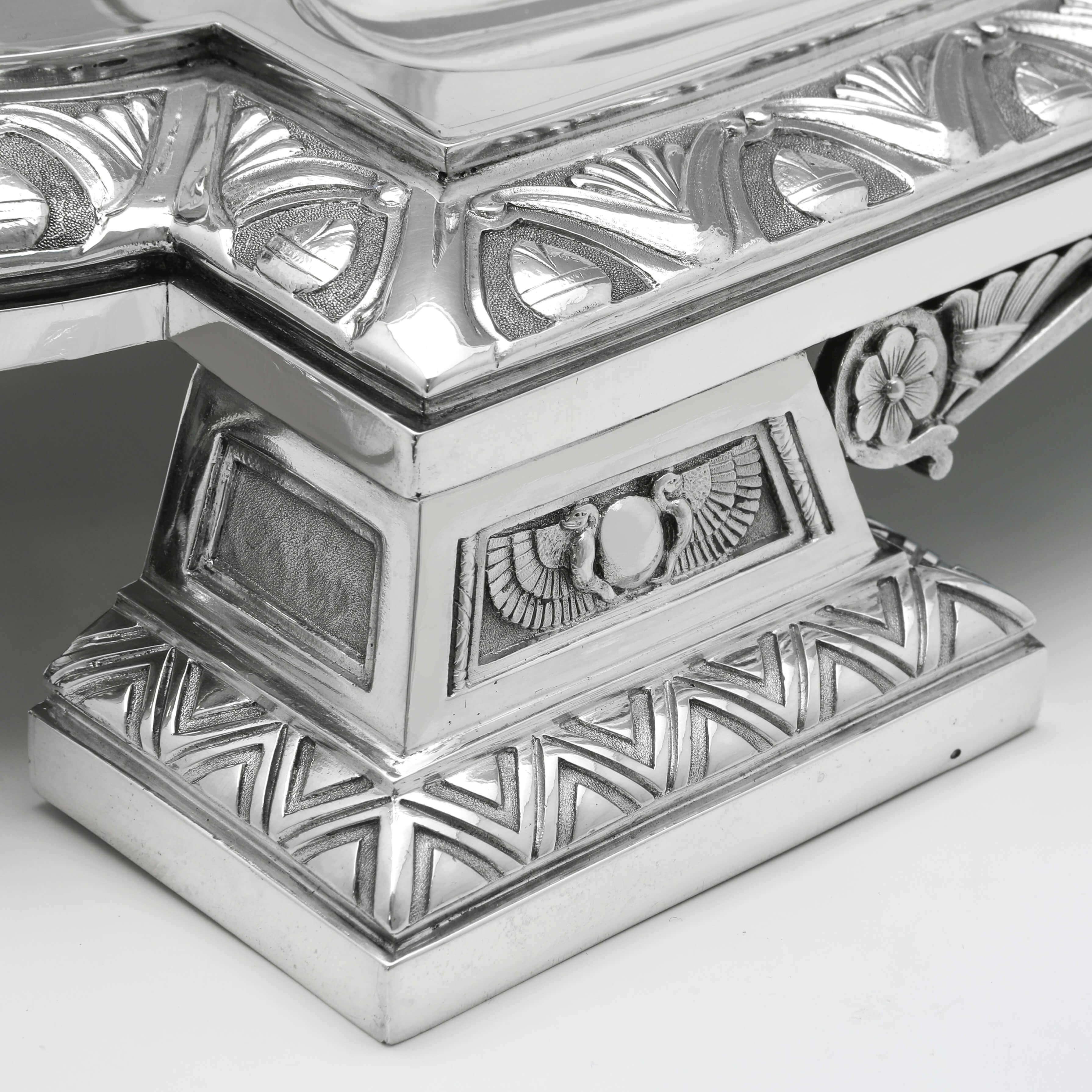 Hallmarked in London in 1908 by Garrard & Co., this monumental Antique, Sterling Silver Ink Stand, is the epitome of Egyptian Revival taste, richly decorated with geometric patterns and Egyptian Motifs throughout. The central storage box is topped