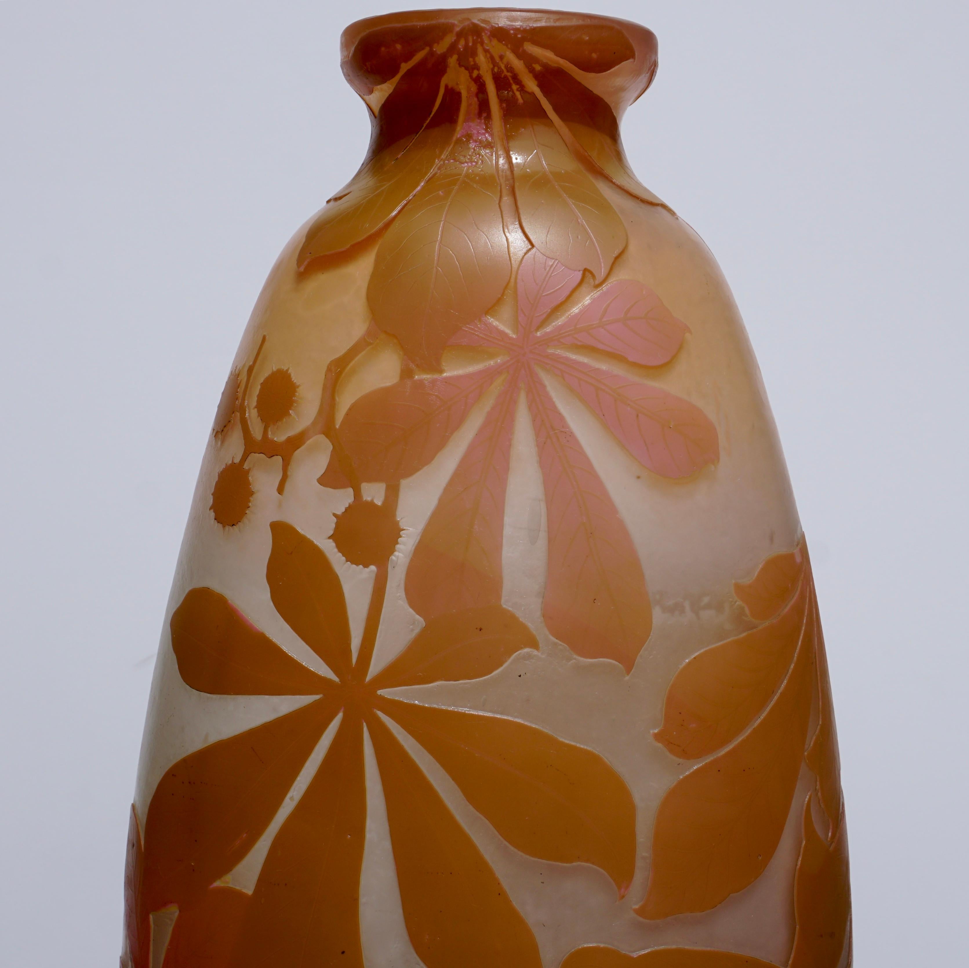 A stunning four color wheel carved and acid etched fat vase with pink, yellow, greenish browns and white on a cream background. The coloring is strong and the workmanship excellent. A truly explosive expression of flowering and seeding botanicals.