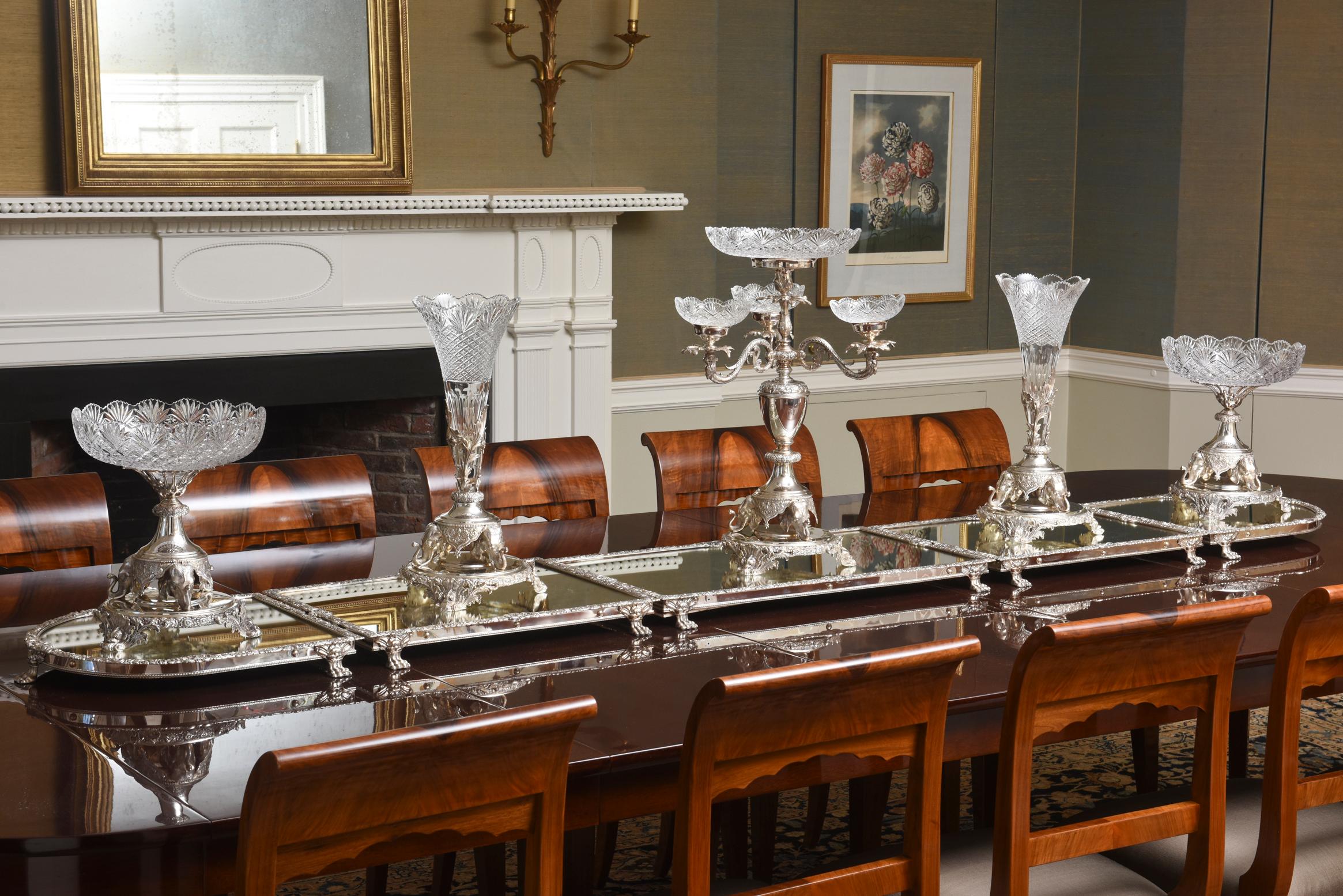 Measuring 8 feet in length, this banquet sized elaborate silver plate and cut crystal centerpiece ensemble is show stopping stunning. It features a 5-piece mirrored plateau having shell and scrolled rim with hall marks for John Turton & Co. A