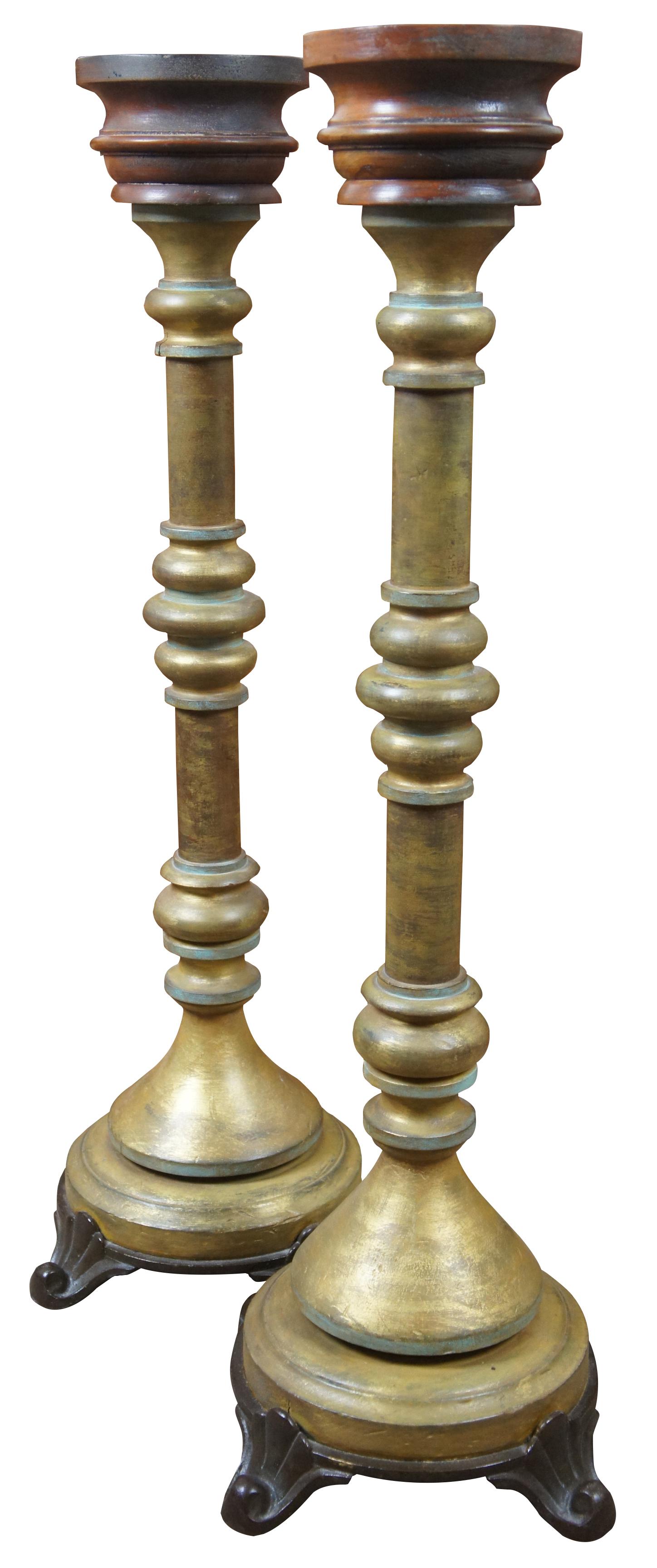 Monumenta pair of 20th century altar candlesticks with iron bases and turned wood pillars, painted to resemble antique patina brass topped with a simple wood drip catcher. Measure: 36