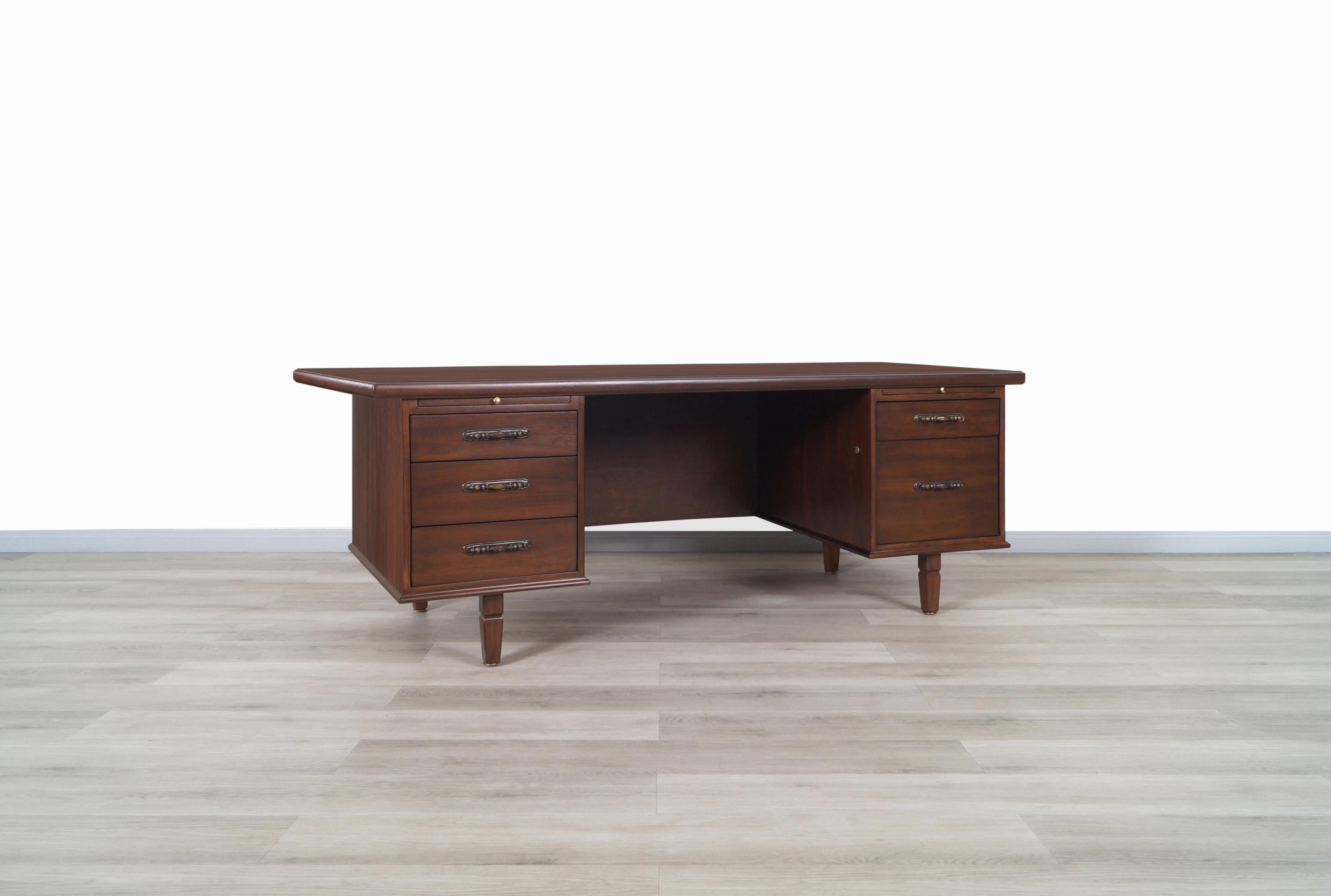 Monumental vintage executive walnut desk designer by Maurice Bailey for Monteverdi Young in United States, circa 1960s. This desk has an innovative design where the peculiar shape of the edges of the top stands out. Features four drawers and a file