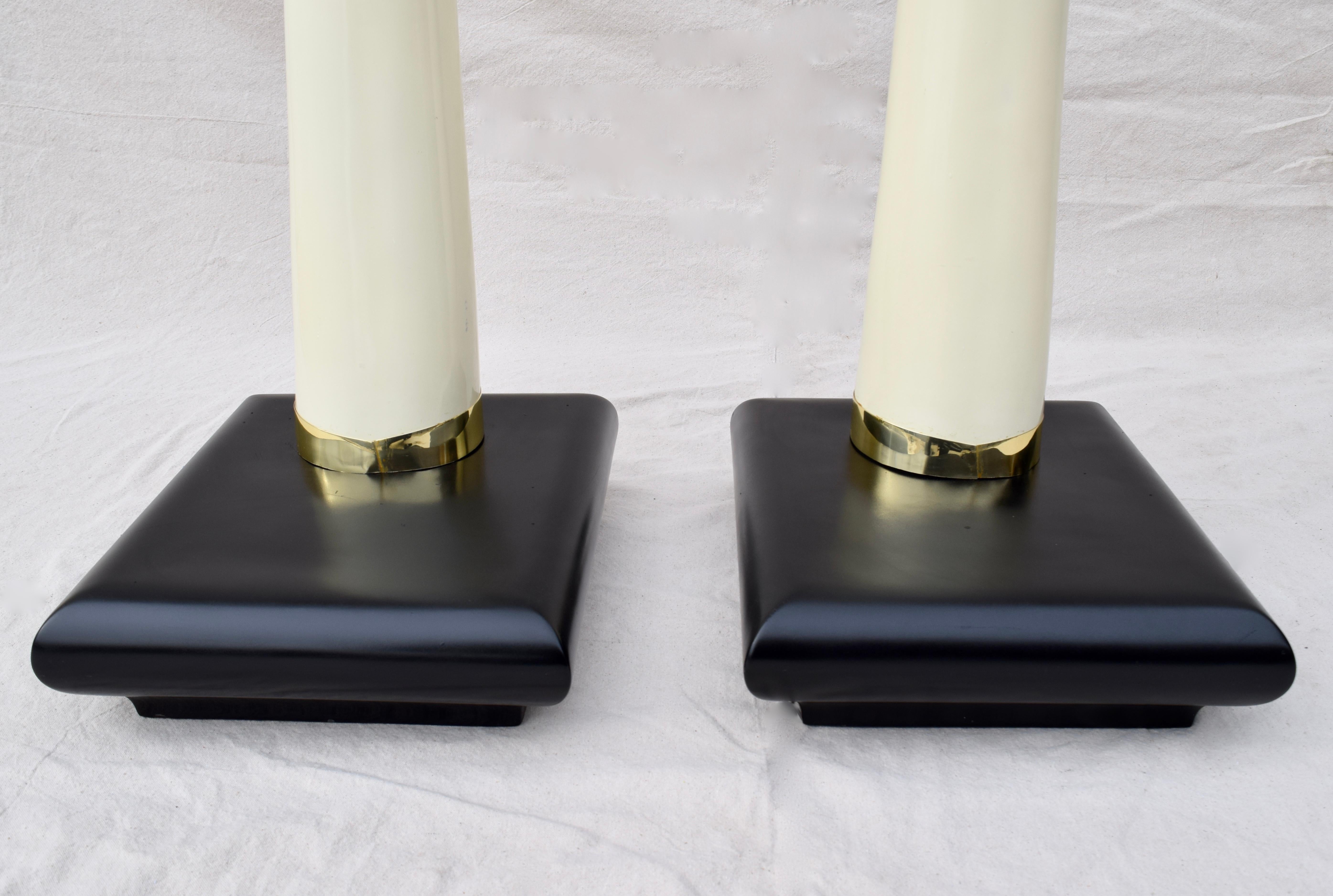 Impressive pair of mid century modern faux tusks of arched monumental form on lacquered wood bases, enhanced with brass collar mounts; circa 1970s. Base dimensions: 18