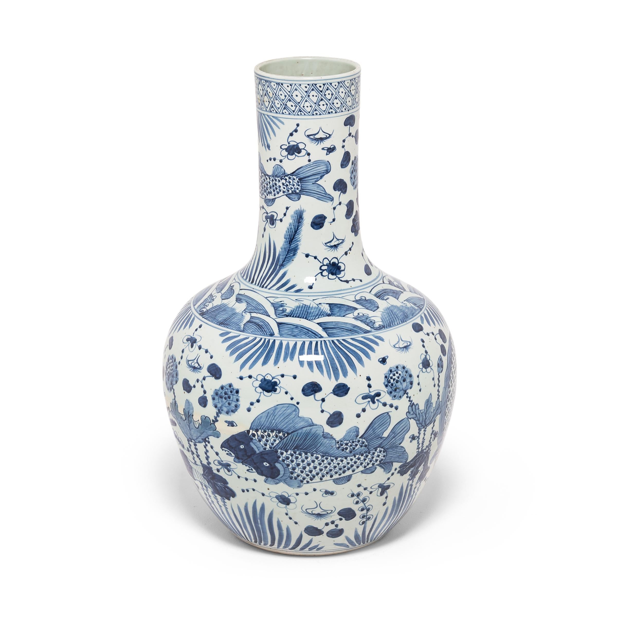 Revered for centuries for its elegant designs and rich cobalt blue and pure white colors, traditional Chinese blue-and-white porcelain lives on in this hand-painted bottleneck vase. Delicately rendered with fish and flora beneath fanciful waves, the