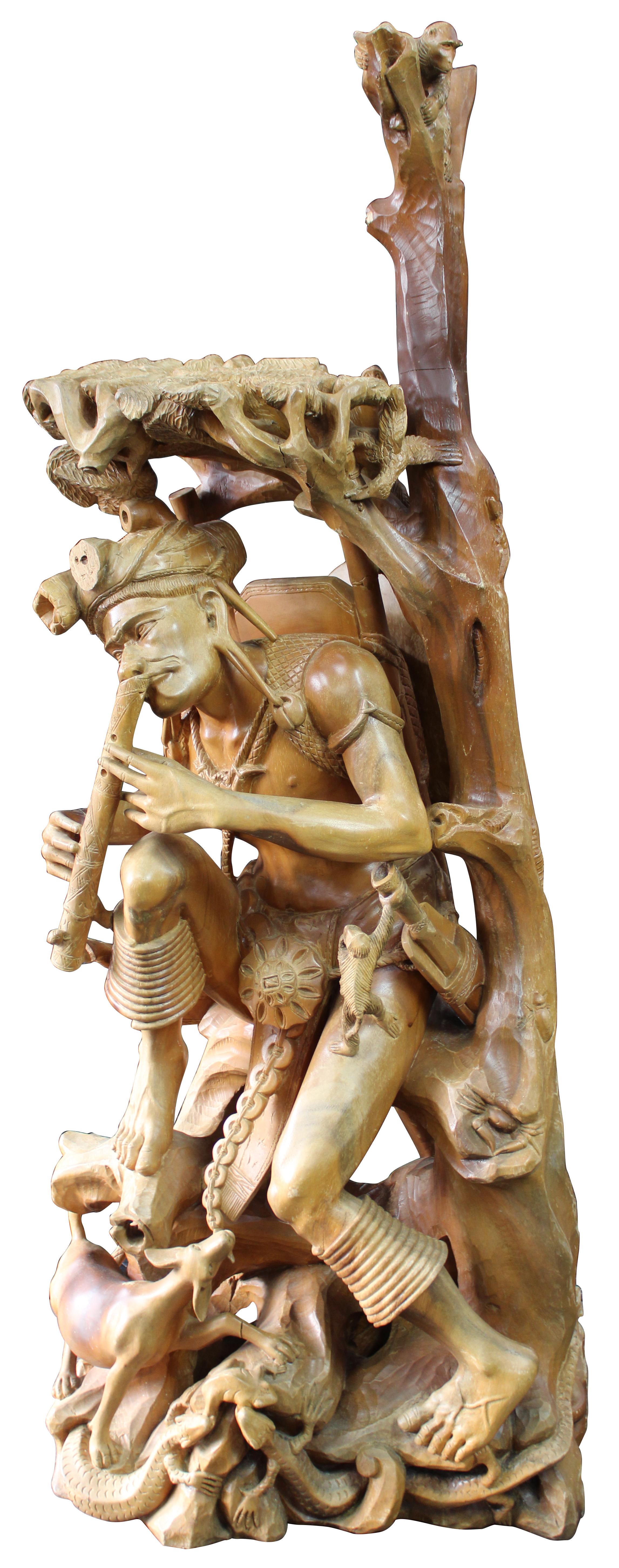 The carving features a man dancing and playing a flute in the treetops with cows / ox, snakes, lizards, frogs, monkeys, a pipe and insects. Carved from one piece. Unsigned.
  