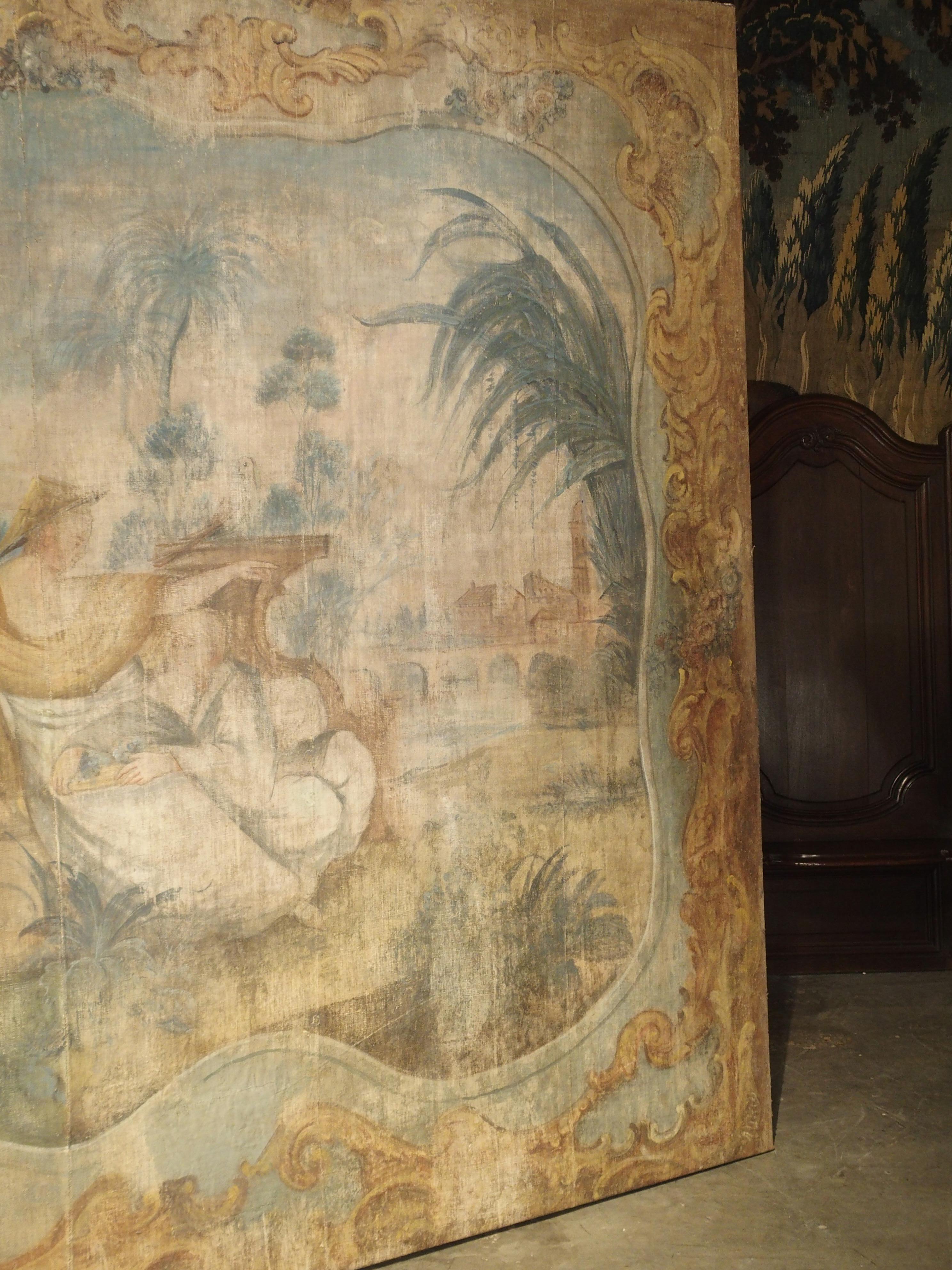 This exceptional French toile peinte (or “painted canvas”) is from the Rococo period, circa 1750. The large chinoiserie scene is composed of eight canvas sections woven together, and it has been affixed to a contemporary wooden stretcher for