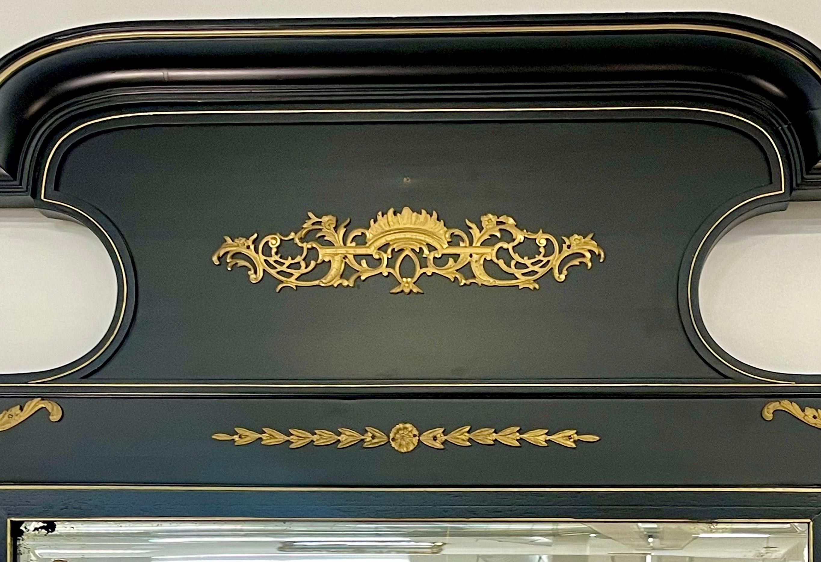 A Monumental French Ebonized and parcel-gilt mirror in the style of Directoire, circa 1950s, the rectangular beveled looking glass with a panelled frame decorated by brass accents.