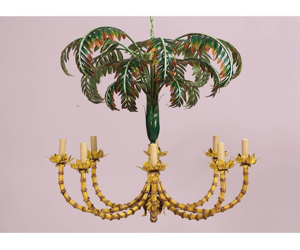 Monumental French, 1960s tole painted iron chandelier in the form of bamboo shoots and palm fronds. Truly a statement making piece. Some paint loss and oxidation.Original wiring is in working condition. Includes new faux-wax candle sleeves. Requires