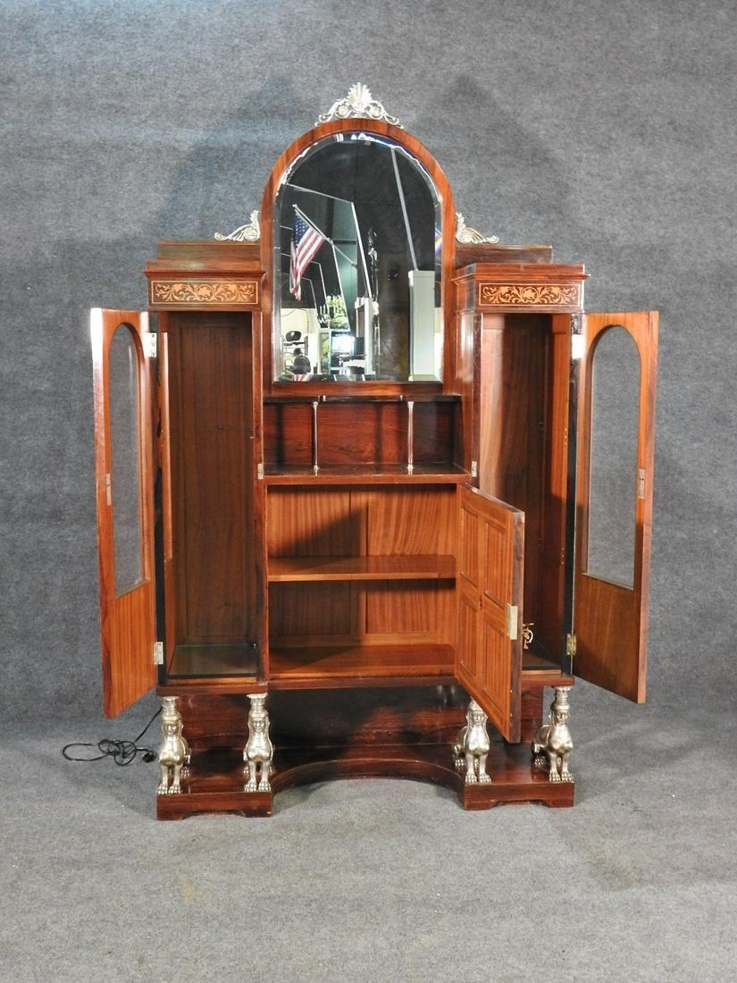 LINGEL KAROLY ES FIAI BUTORGYAR rosewood. Budapest. Inlaid accents. Metal. Figural. 2 beveled glass doors containing 2 glass shelves. 1 wood door containing 1 shelf. Beveled glass mirror top. Lighted, circa 1890. Measures: 82