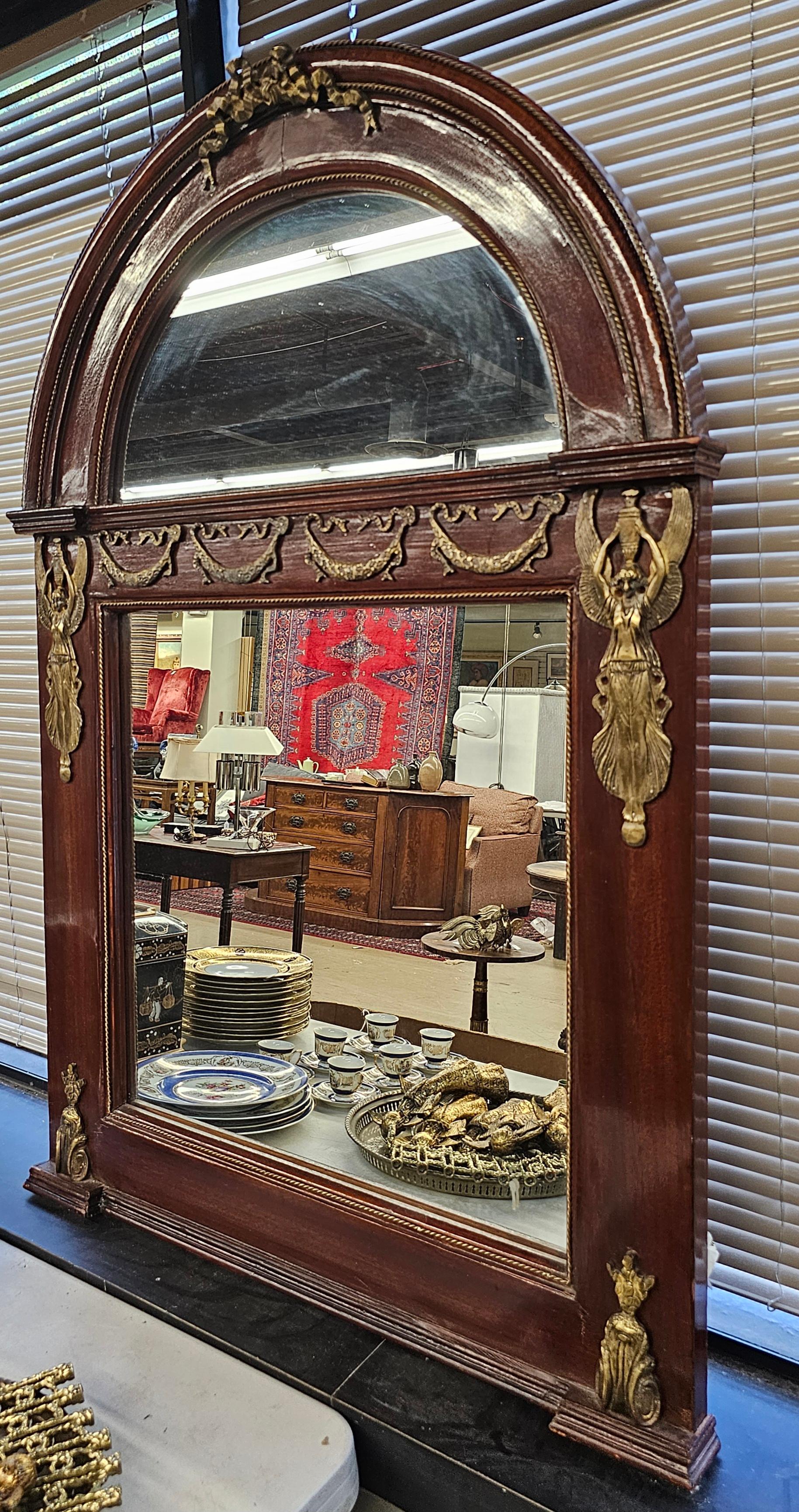 Monumental miroir néoclassique français en acajou richement monté et décoré de bronze doré. 
Cadre en acajou massif verni. Support en bois.