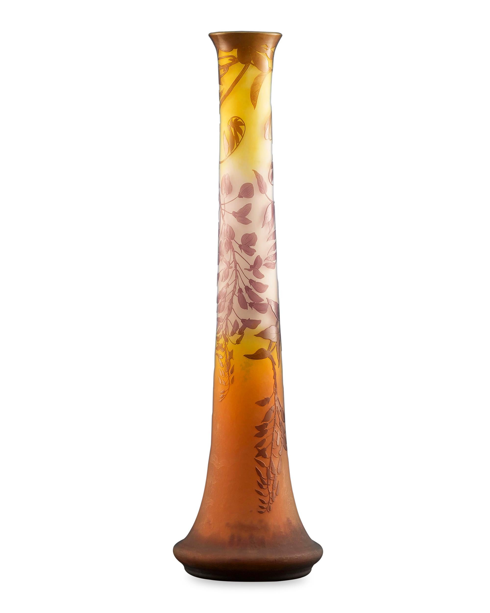 Monumental size and outstanding artistry distinguish this grand cameo glass vase by Emile Gallé, one of the most highly regarded names in French glassmaking. This majestic vessel displays warm amber tones and is graced with an etched and