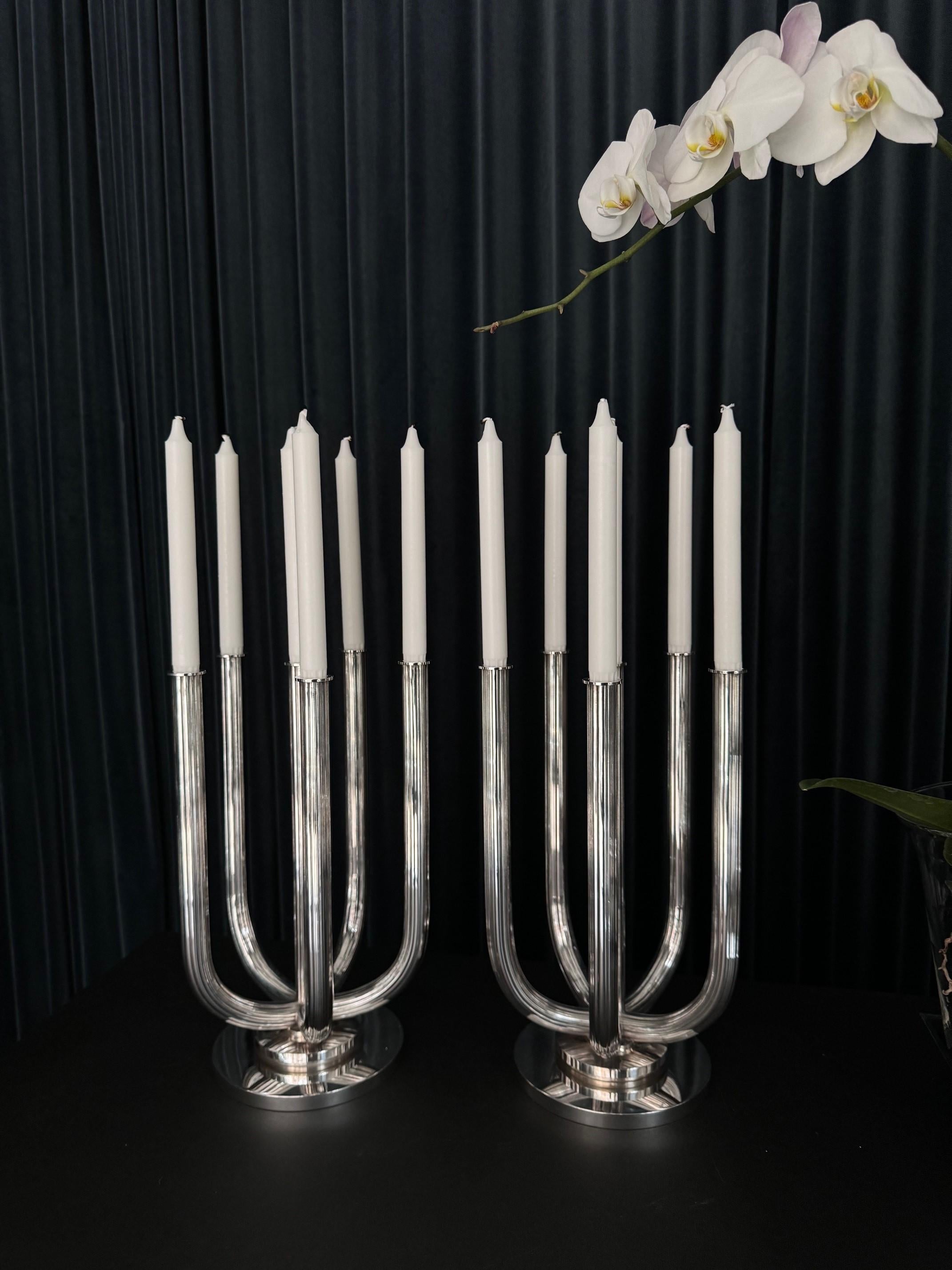 A pair of vintage monumental candelabra from Georg Jensen, model #751, designed by Harald Nielsen in 1935. These exquisite pieces feature an oversized disk-shaped raised base with a centered smaller disk. The six tubular arms showcase a meticulously