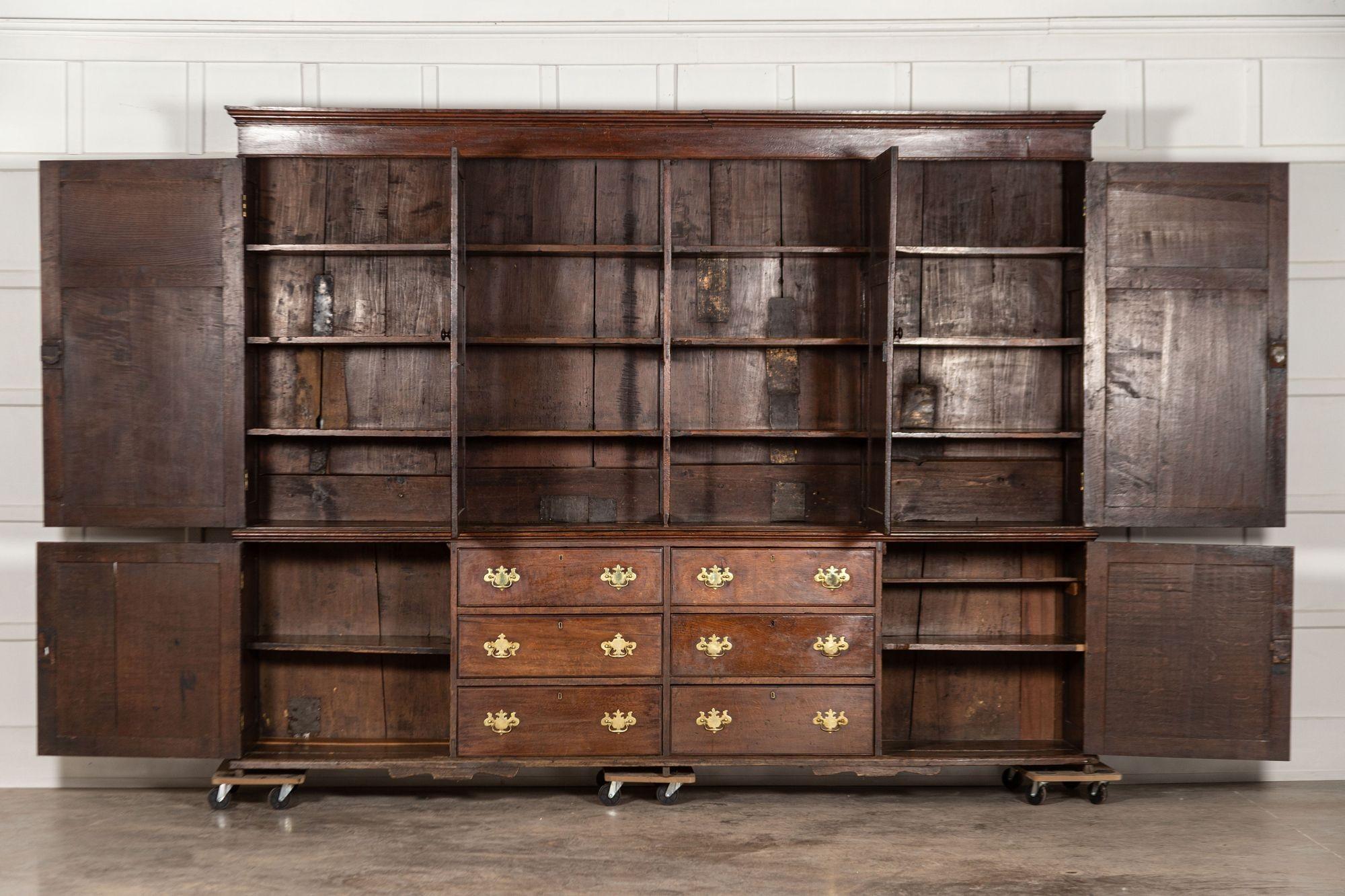 circa 1800
Monumental George III oak housekeeper's cupboard
The narrow ogee cornice above a plain frieze and four cupboard doors with fielded panels, opening to fixed shelves, the base with six graduated drawers flanked by further cupboard doors