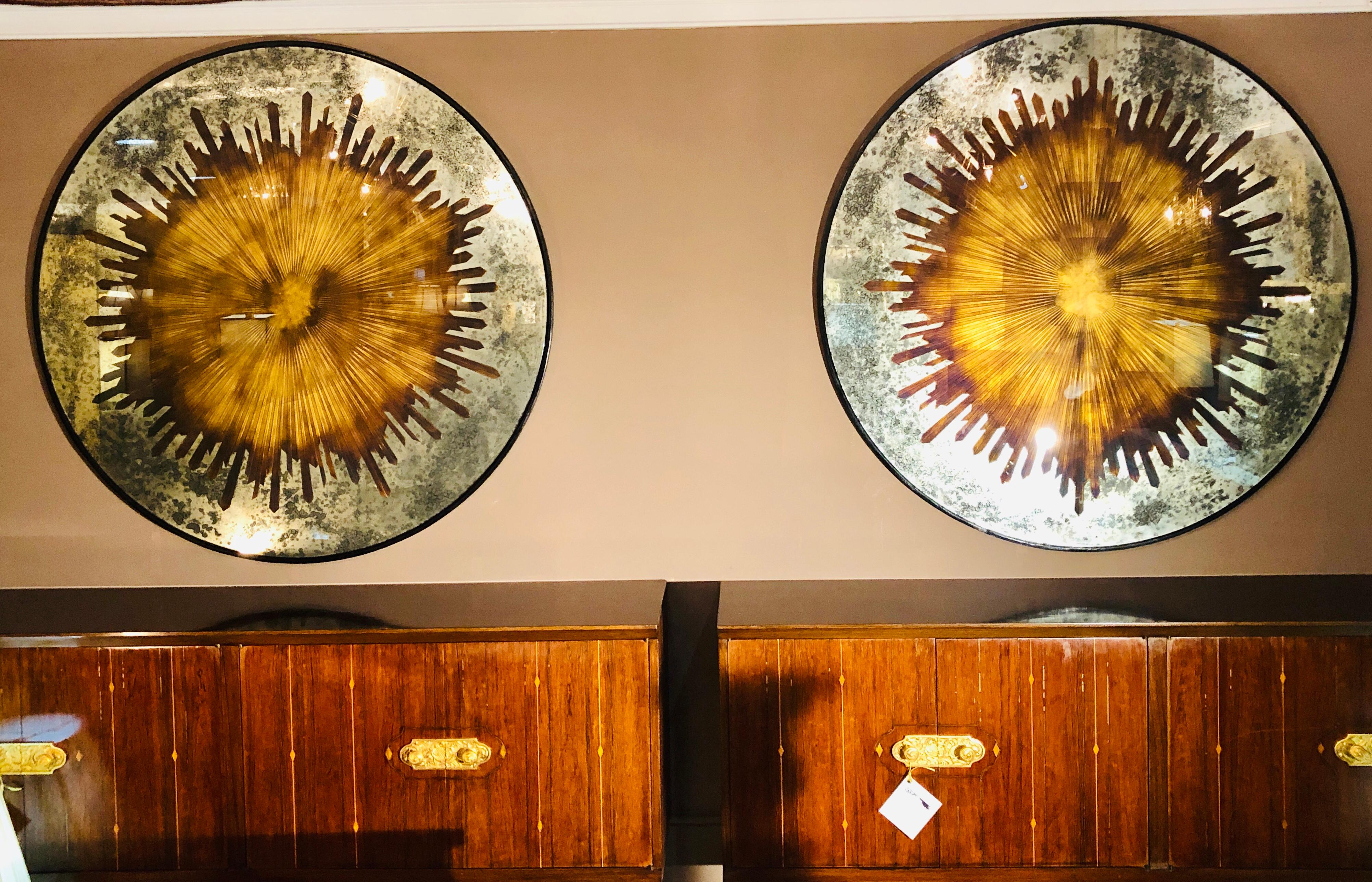 Pair of monumental carved gilt gold and silver glass Art Deco sunburst wall mirrors or table tops. These spectacular finely decorative mirrors would make a splash weather hanging on the wall or sitting upon a metal table base. Can easily be used as