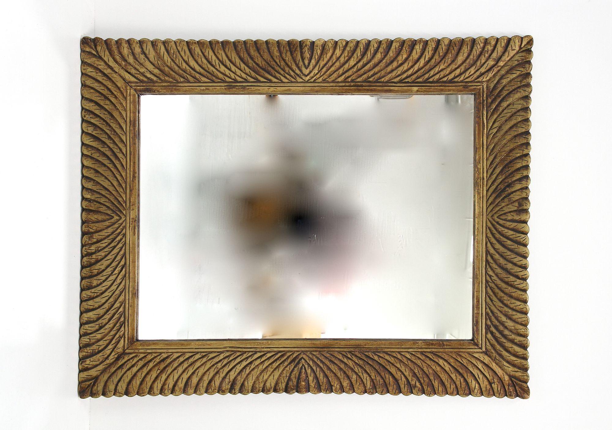 Monumental gilt mid-century wall mirror from the period around 1940/50 in Italy. This exceptional mid 20th century Italian wall mirror impresses with its massive, artfully handcarved frame showing an absolutely fantastic looking pattern with a