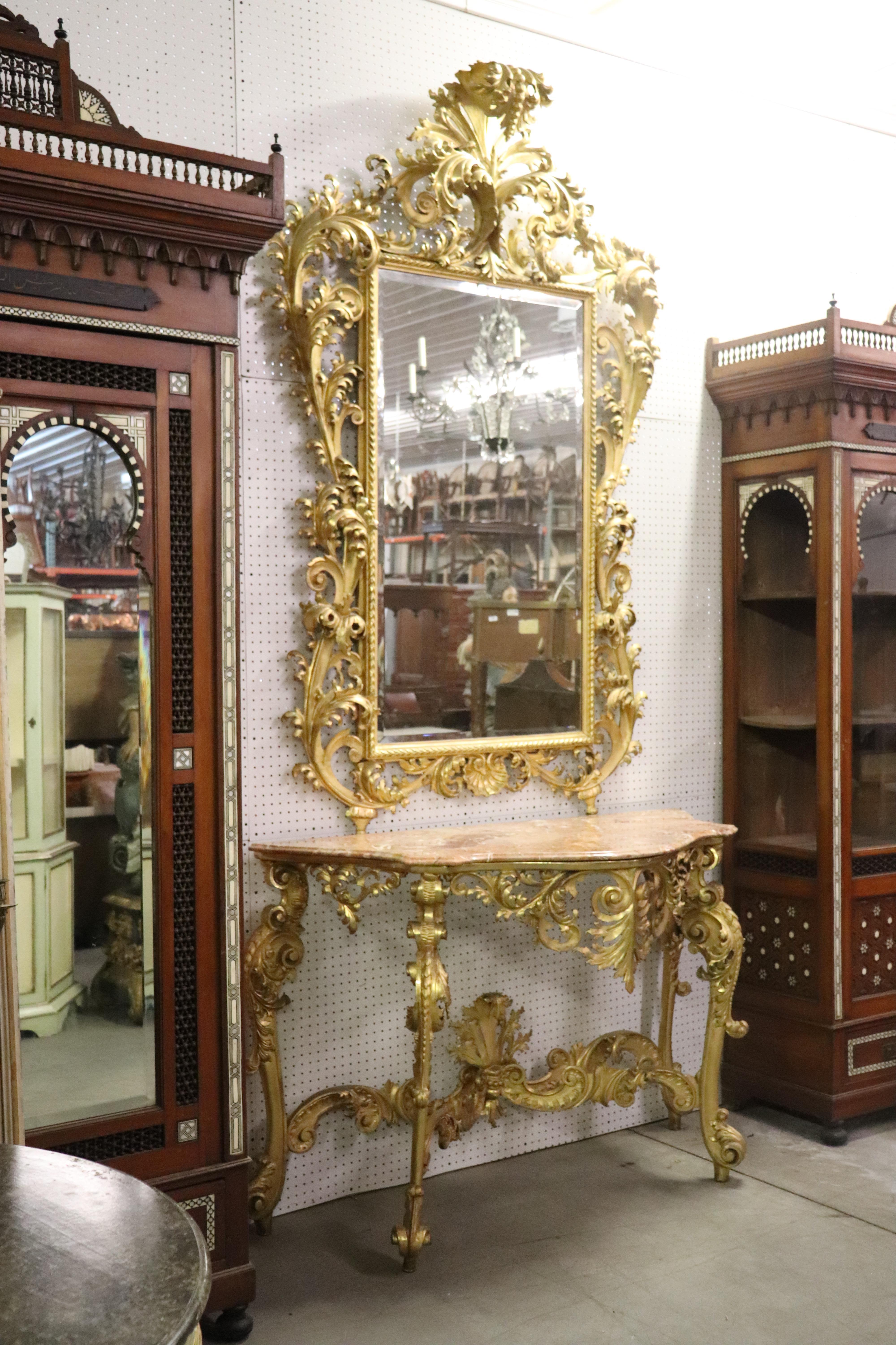 This is a monumental mirror and table. This incredible pair was hand carved and beautifully water-gilded for the brightest possible gold finish in Italy. The workmanship is stunning and beyond compare.
The mirror itself measures 81 tall x 56 x