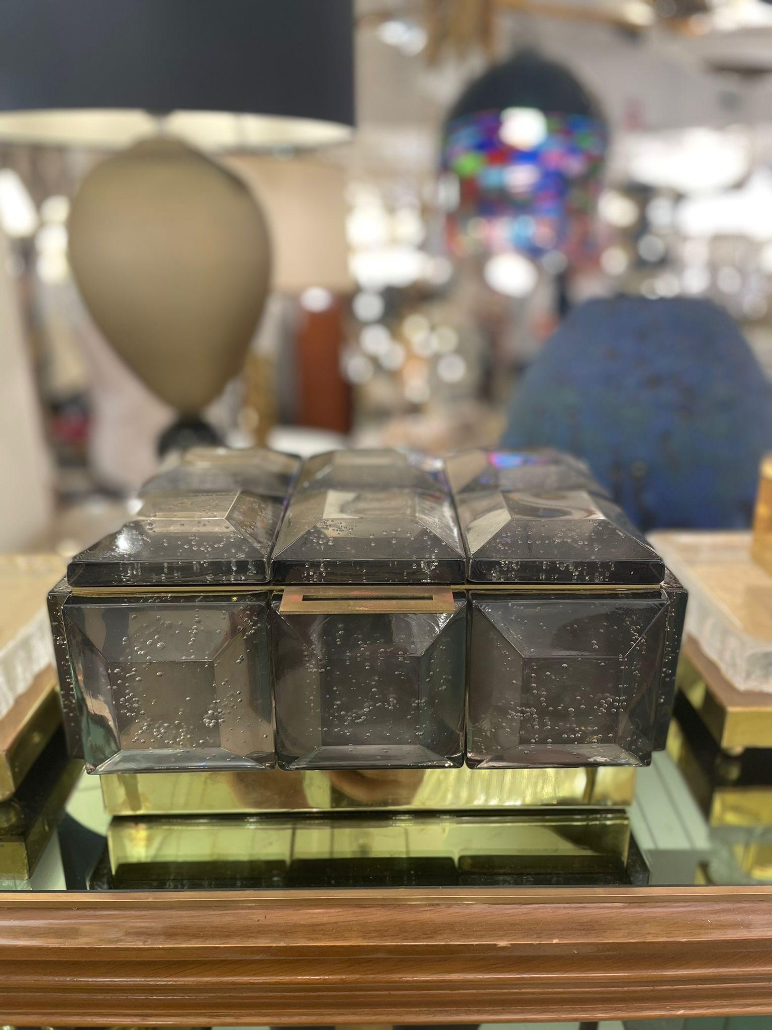 A monumental box in grey Murano glass with polished brass inner core.