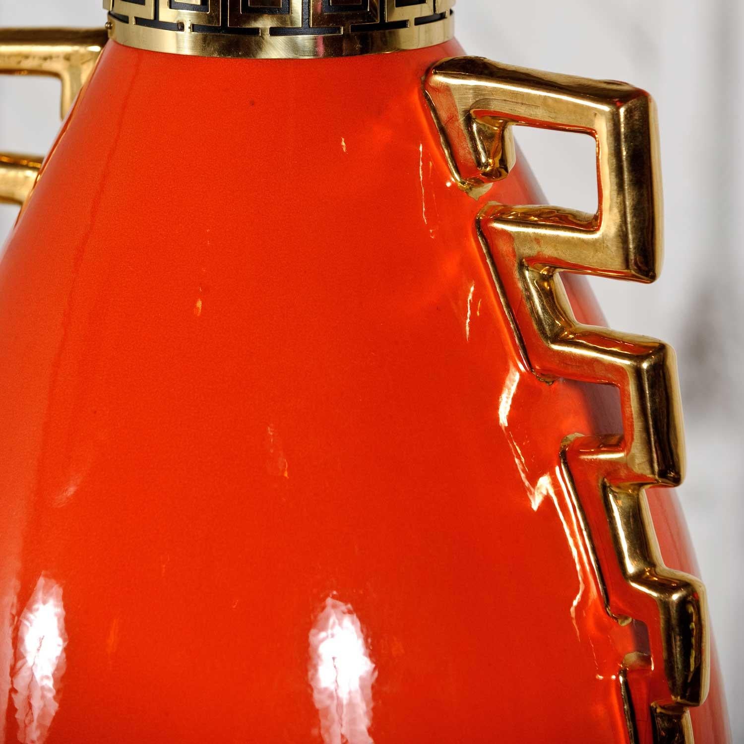 Gorgeous monumental Hollywood Regency bright red-orange and gold glazed ceramic lamp which is in the style of the infamous James Mont. It is in wonderful vintage condition with no outstanding flaws to the lamp itself. The huge black shade with