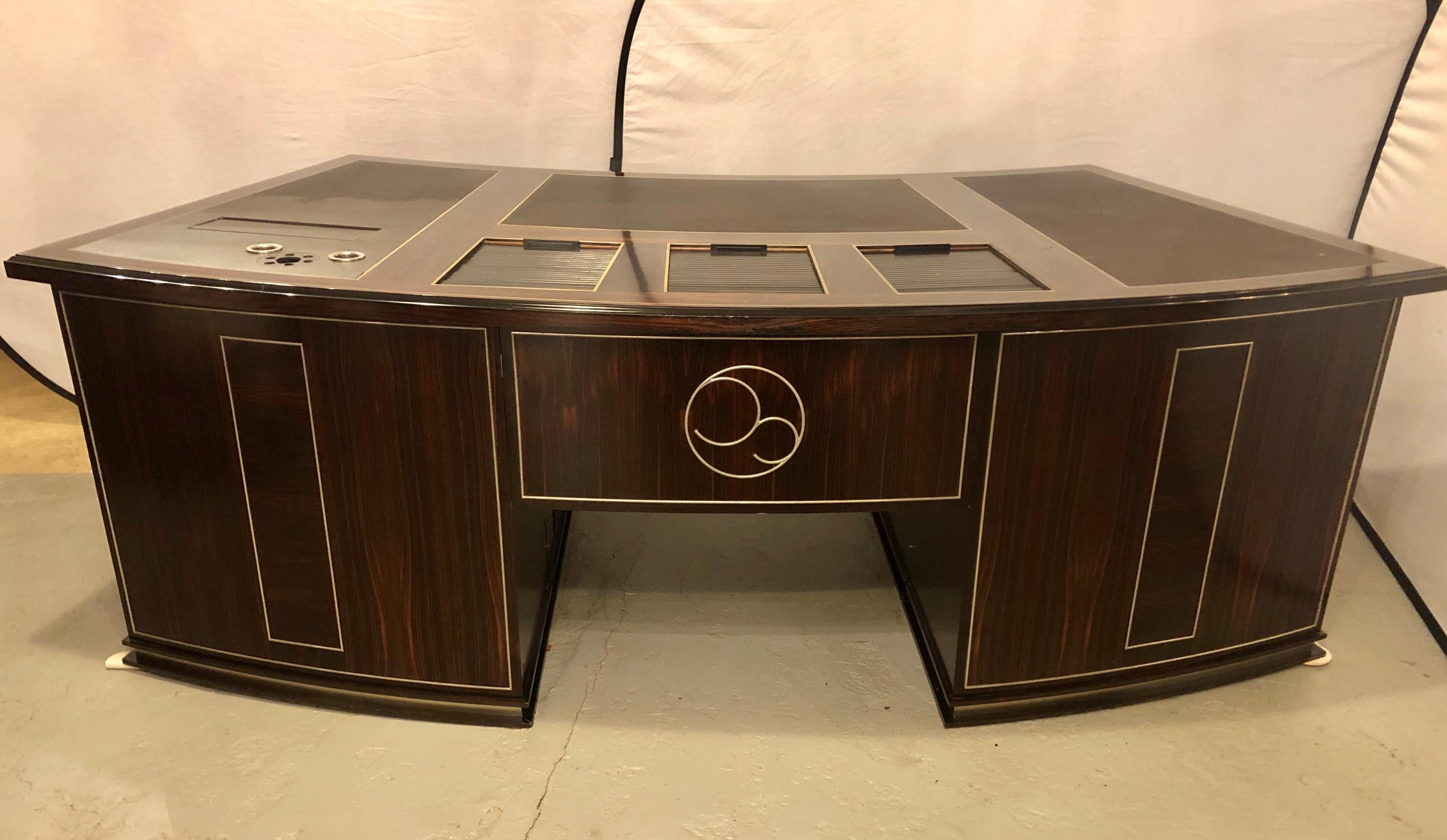 Large and impressive custom (most likely Dakota Jackson) executive's or partners desk, late 20th century, in rosewood veneers, curved form, top with inset grained leather panels, brass string inlay, three tambour doors opening to storage and