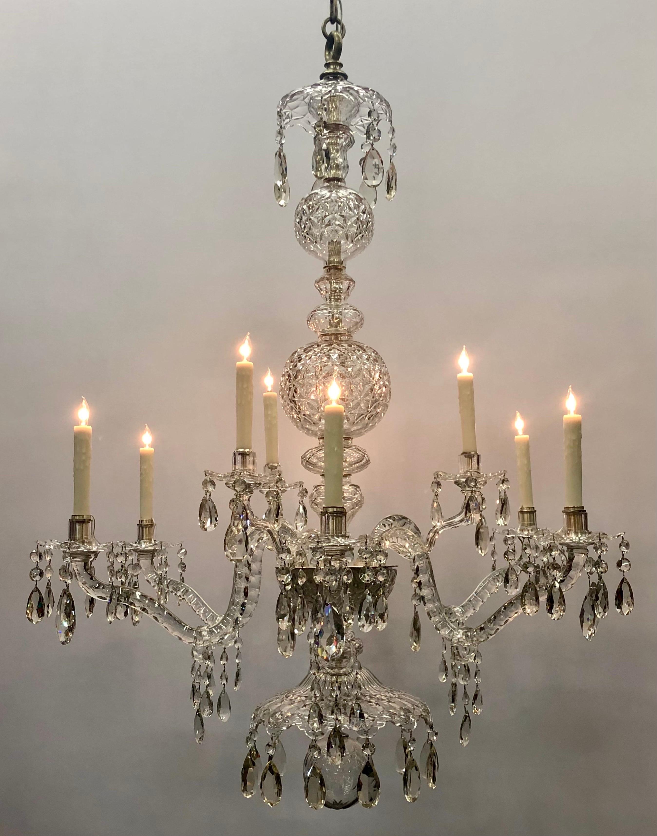 Monumental 19th Century Irish Crystal Georgian Nine Light Chandelier.   The Refined Anglo-Irish Chandelier has lead crystal stem-pieces comprised with shallow relief cut diamond nesting sections of shaped pieces and  two graduated relief cut