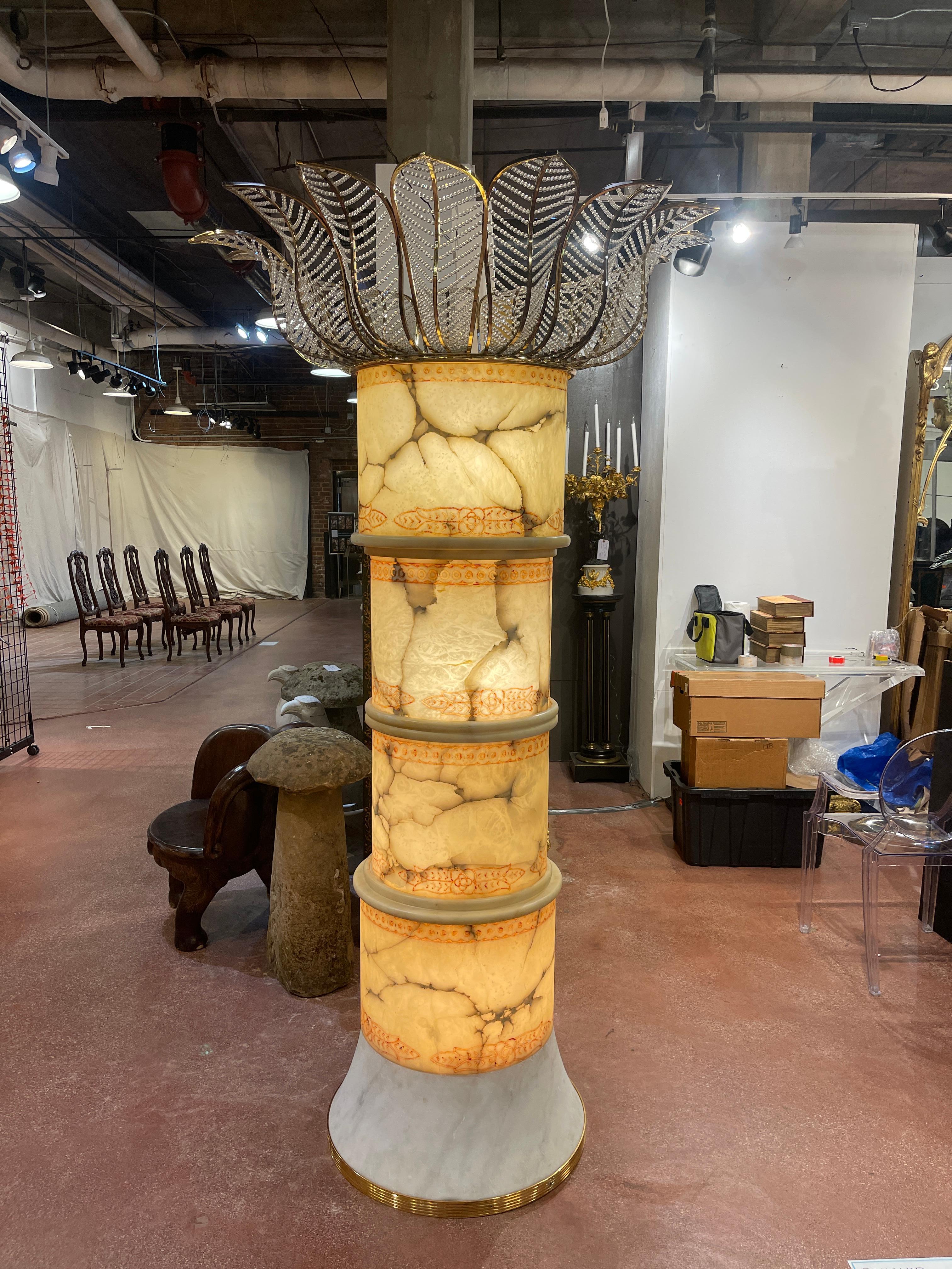 Monumental Italian alabaster, marble, brass & crystal palm tree floor lamp
This commanding lighted sculpture, with 45-Inch diameter brass and beaded crystal palm fronds, raised on a column of four carved and polychromed alabaster sections, resting