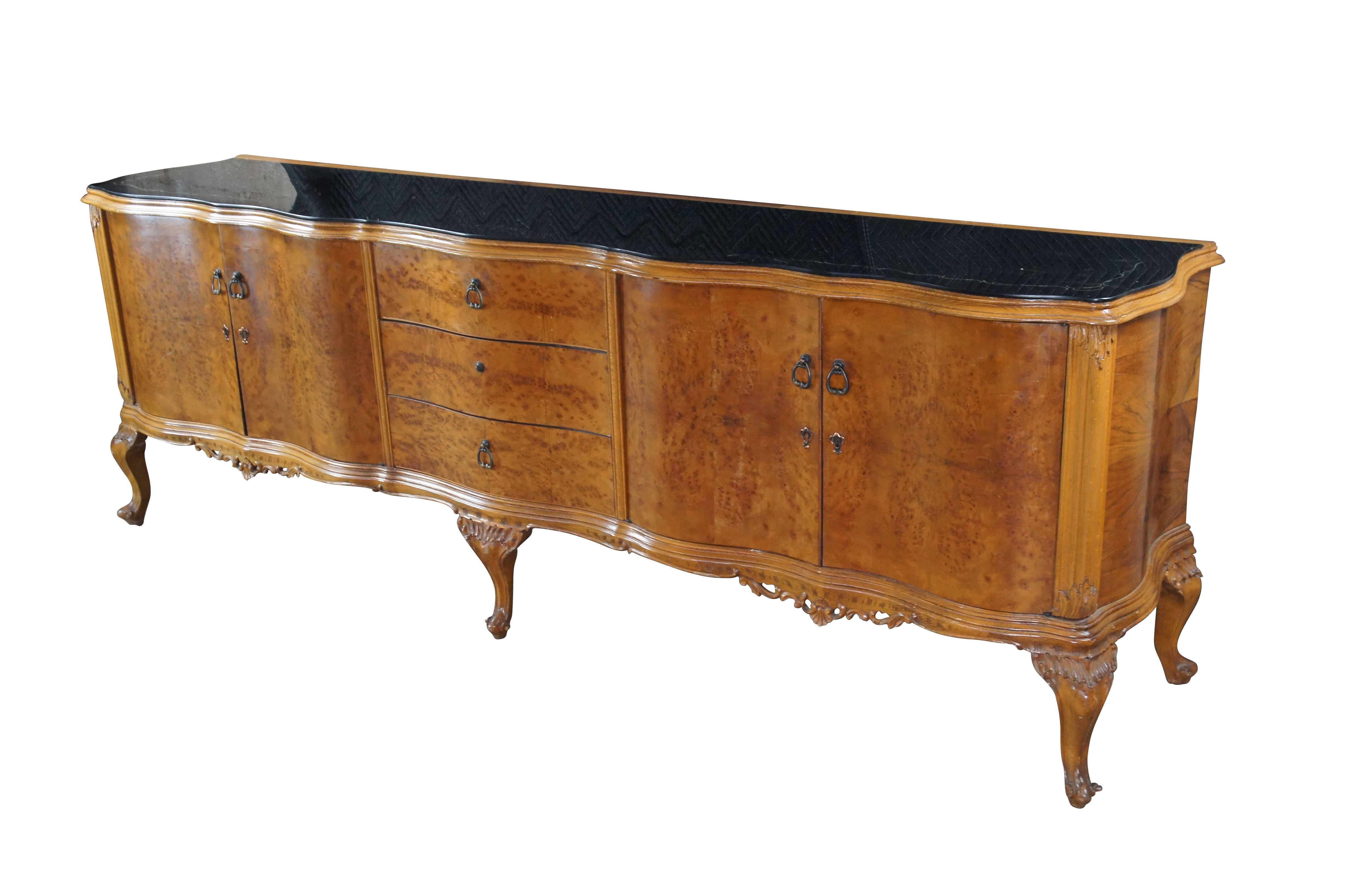 Una grande e imponente credenza italiana barocca veneziana di 8,5 piedi, circa 1920.  Ha una forma a serpentina con piano in vetro nero su una cassa in radica di noce impiallacciata a libro di fiammiferi con tre cassetti centrali a coda di rondine