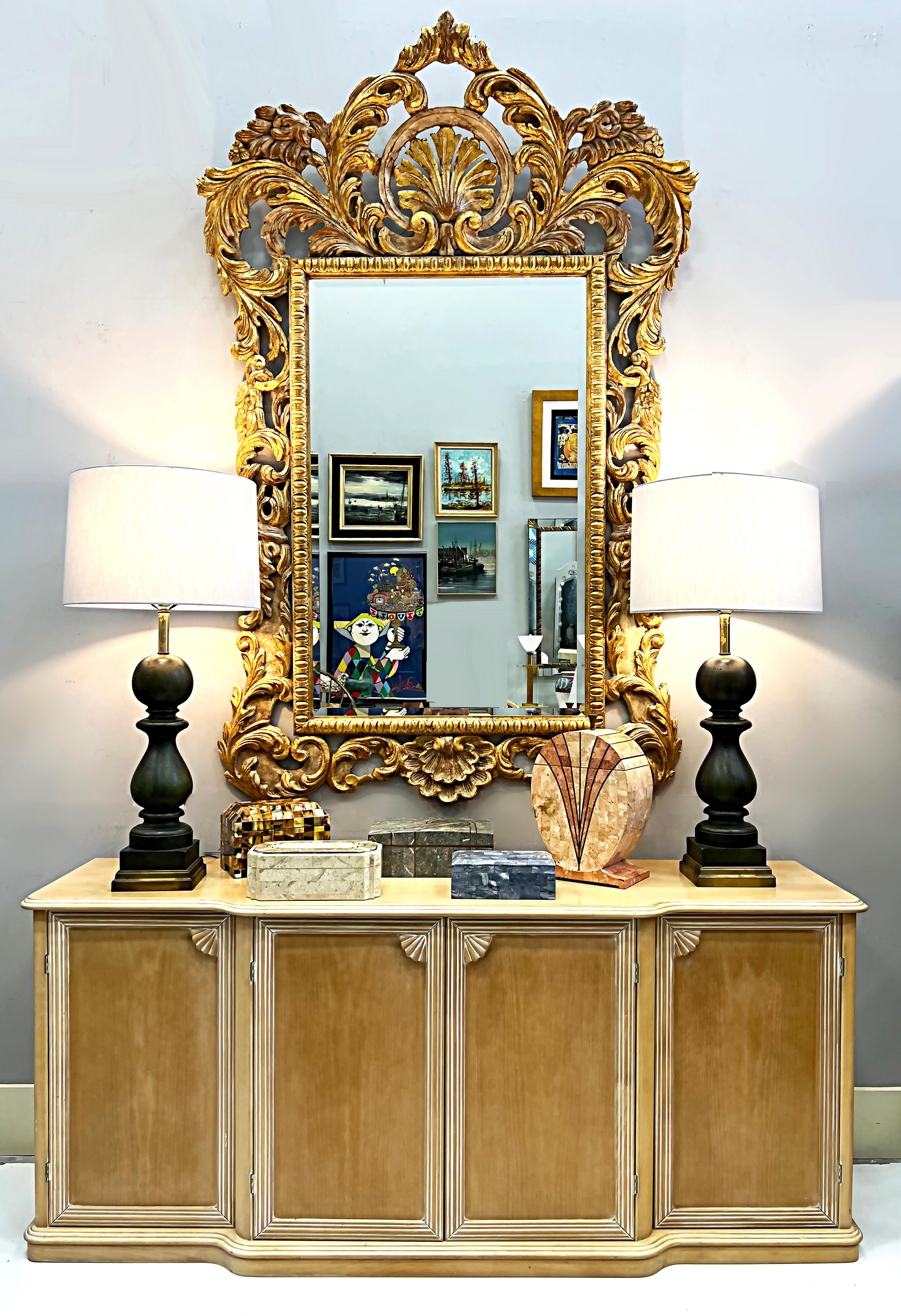 Monumental Italian Carved Gilt Wall Mirror, Hollywood Regency Style 
 
Offered for sale is a monumental and elegant Italian Hollywood Regency-style carved giltwood wall mirror with ornately carved leaf and shell motifs. The mirror has a
