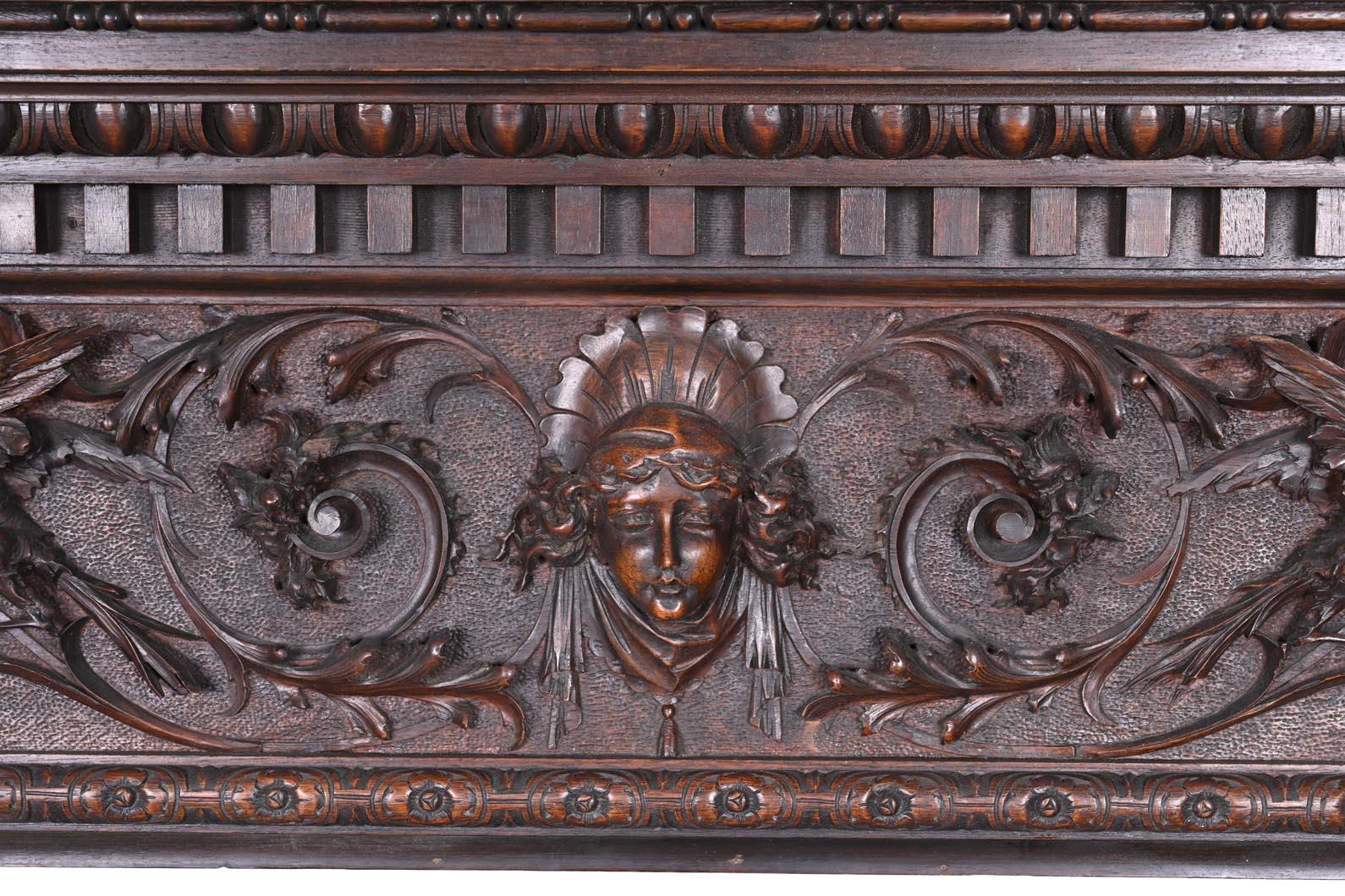 Imposing architectural fireplace from Italy, finely carved in dark walnut and featuring two powerful antique-style atlantes supporting an elaborately decorated entablature. The bearded male figures, sculpted in the round, show expressive musculature