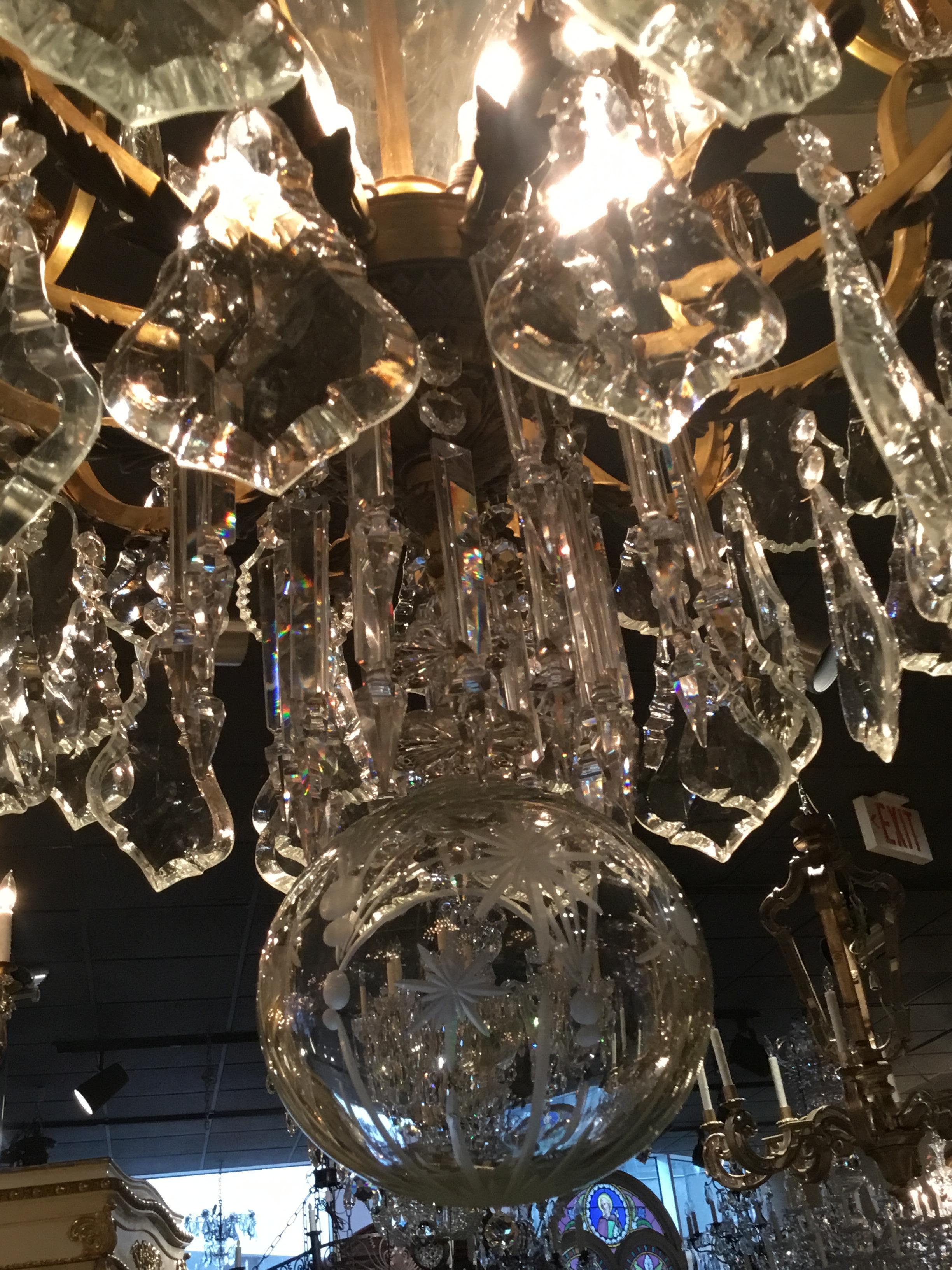 Incredible large bronze and crystal chandelier with etched crystal stem
And etched crystal ball. Large shaped crystals with draping adorn this
Spectacular piece. Eight up lights and twelve candle lights surround
The perimeter to make the lighting