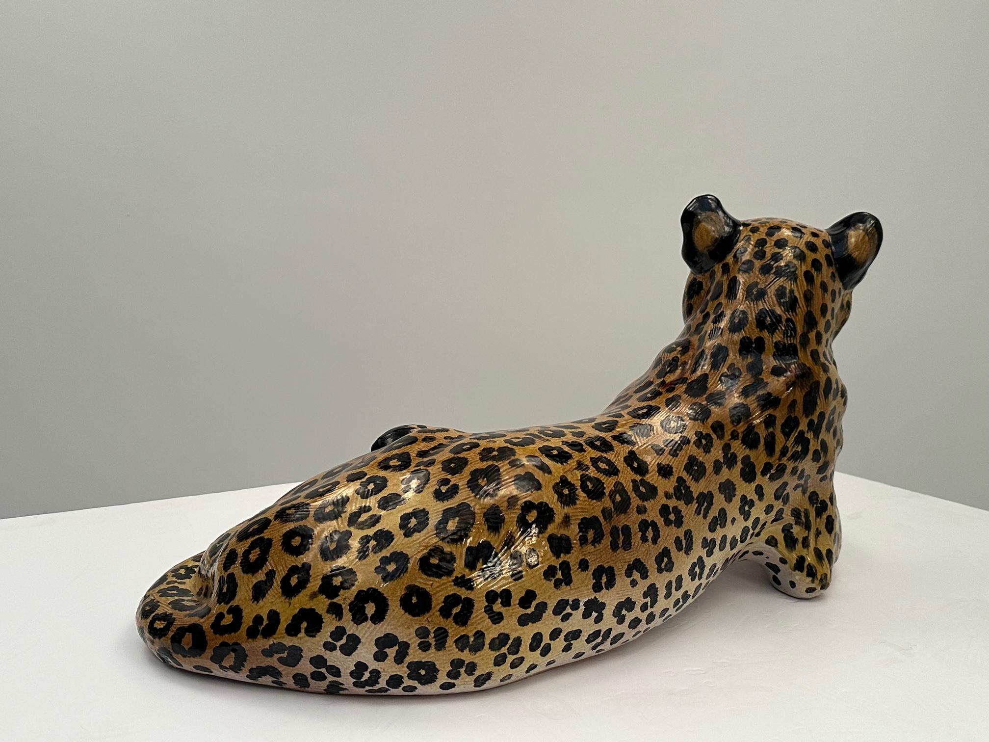 Impressionnante sculpture italienne de léopard en terre cuite peinte et émaillée, en position allongée.  Les détails du visage, des pattes, de la queue et, bien sûr, du pelage tacheté sont superbes !