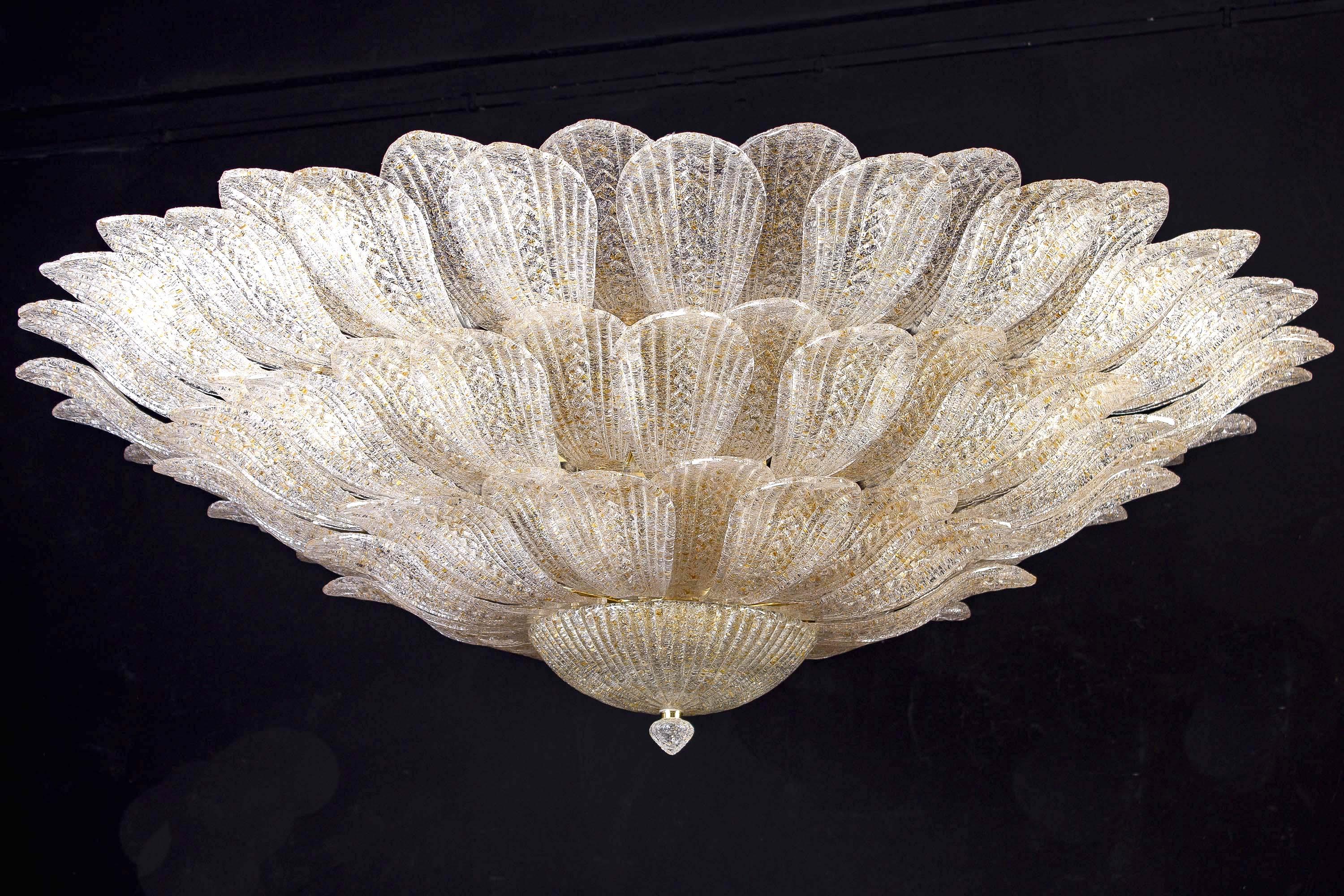 This striking ceiling light is realized in pure Murano glass, each chandelier consists of an incredible number of leaves with gold intrusion.
Gold-plated frame with 18 E 27 bulbs spread a magical light.
Available also a pair.
By Galleria