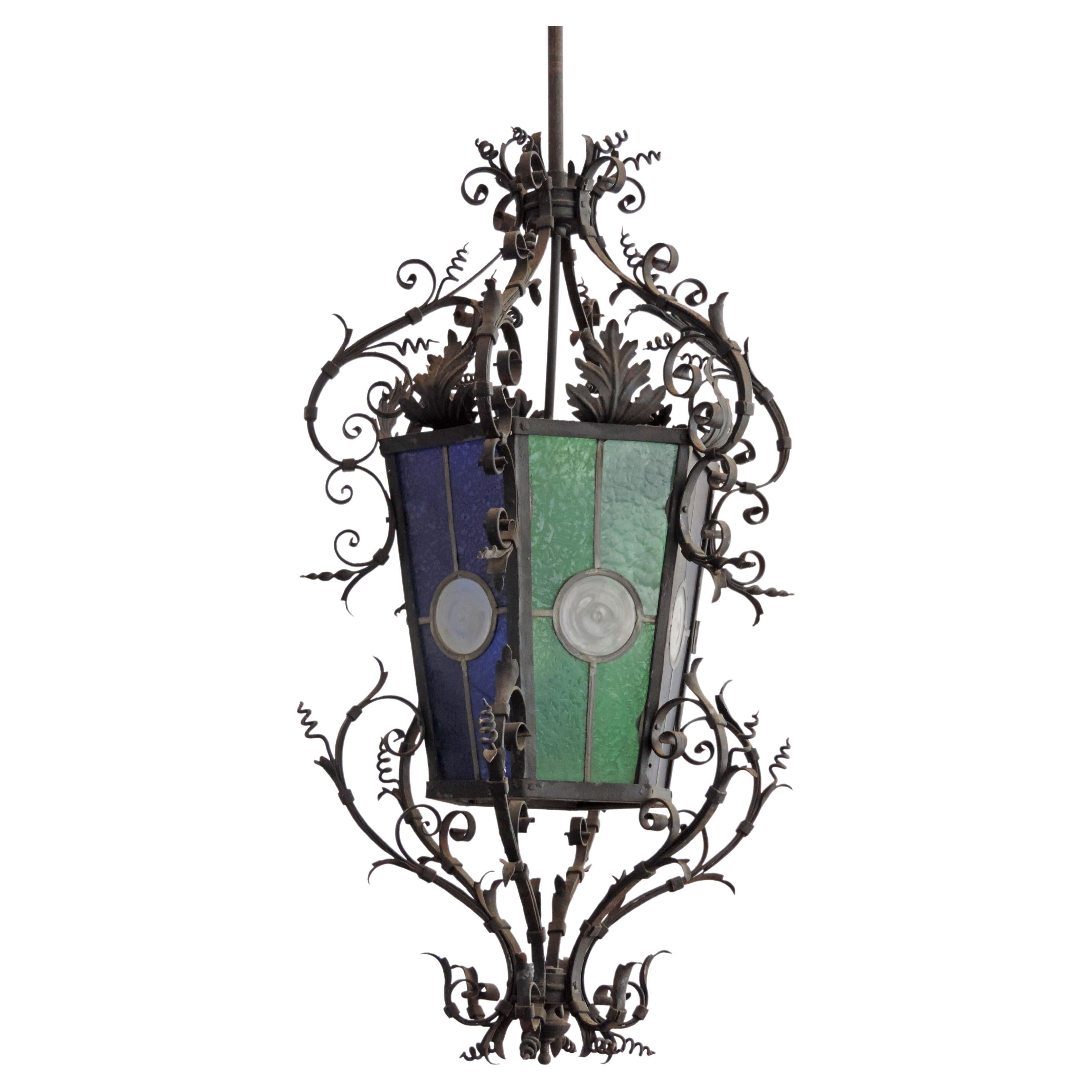 Monumental Italian Gothic style lantern in wrought iron and two colored blue and green stained glass.
The Lantern is measures 220 x 60 cm 
Lantern Body Without Pole Measures 91 x 60 cm
An Exceptional addition for Indoors or Outdoors.
Carries two