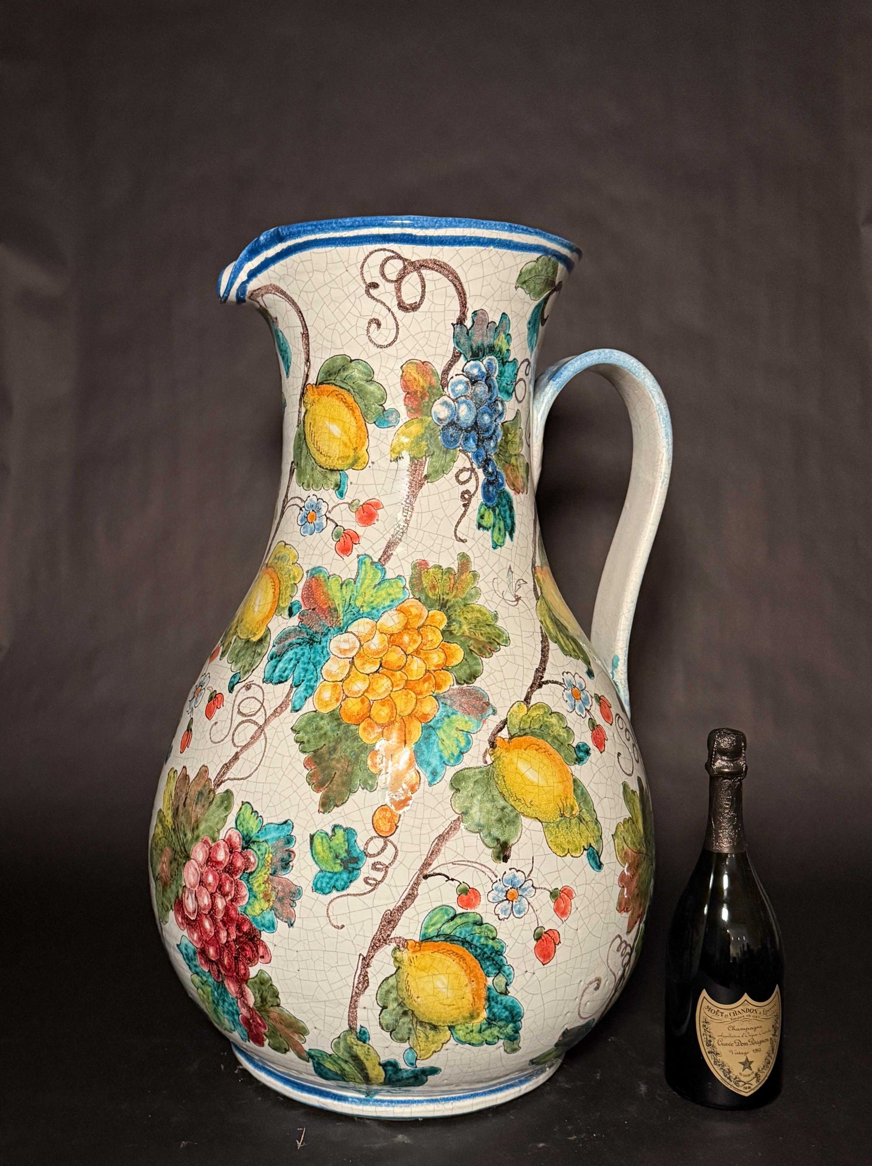Jarra muy grande de cerámica mayólica italiana de Armando Poggi, Florencia, Italia. Pintura a mano decorada con uvas de colores en parras junto con grandes limones gordos. Una bonita decoración para cualquier cocina o zona que quiera aportar  un