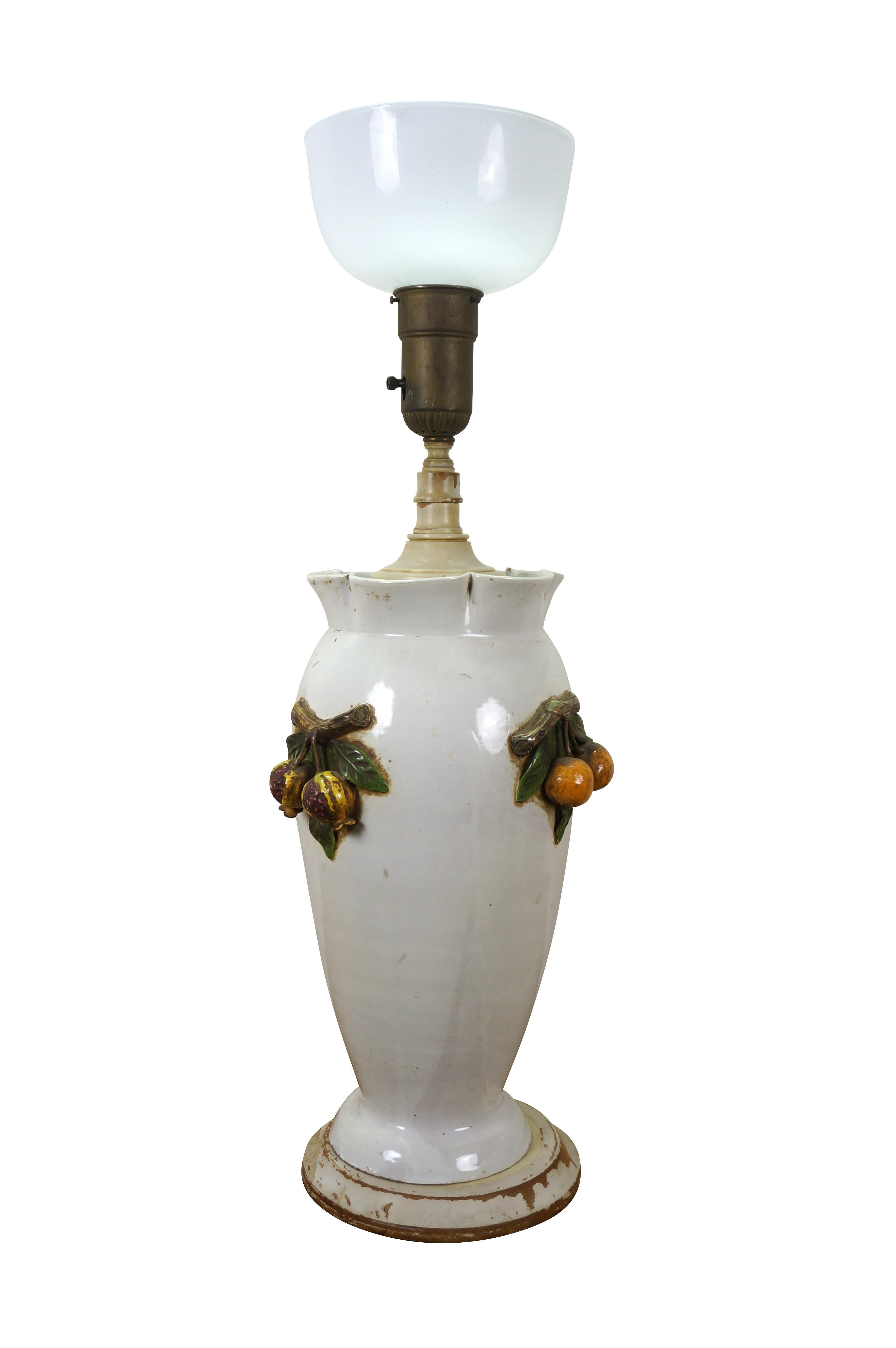 Très grande et impressionnante lampe de table en porcelaine italienne du milieu du 20e siècle, présentant une urne / un vase à la cime ébouriffée avec des branches de différents fruits appliquées de chaque côté, un col et une base en bois tourné, et