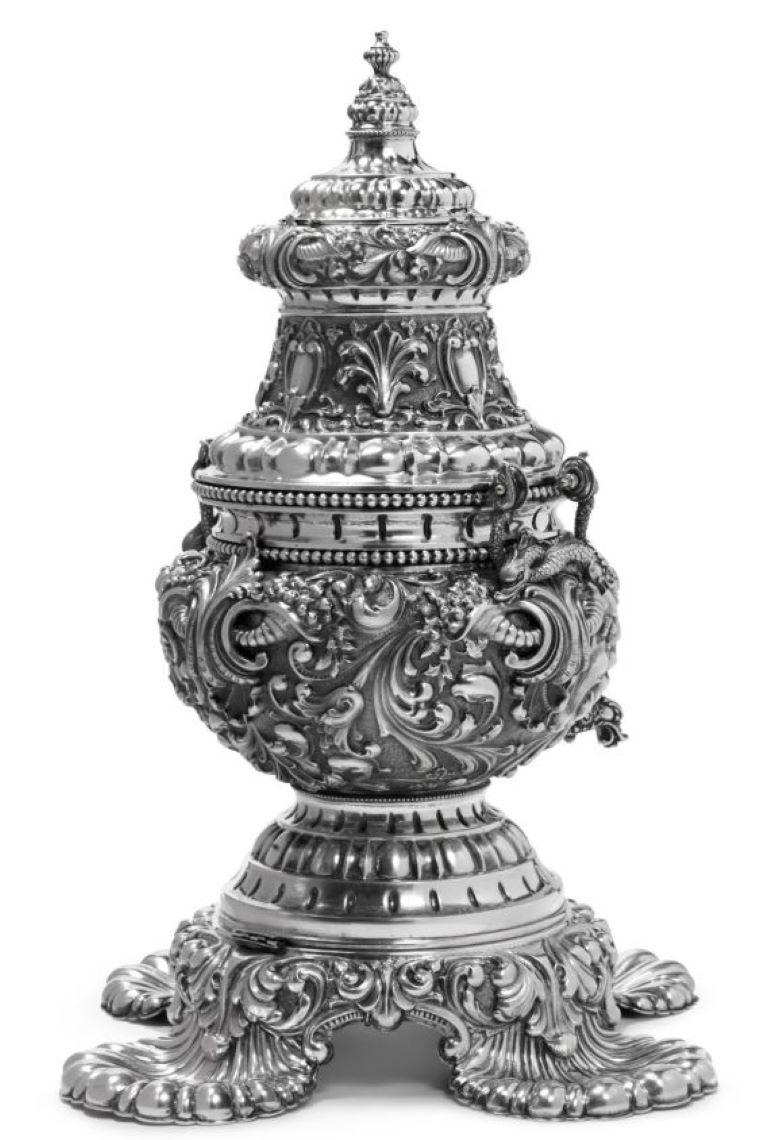 Exceptionally well crafted and monumental continental silver samovar, made in Milan in the 20th century, densely chased and embossed, on a matching stand raised on four large shell-form feet, base fitted for electricity. It measures 25'' in height